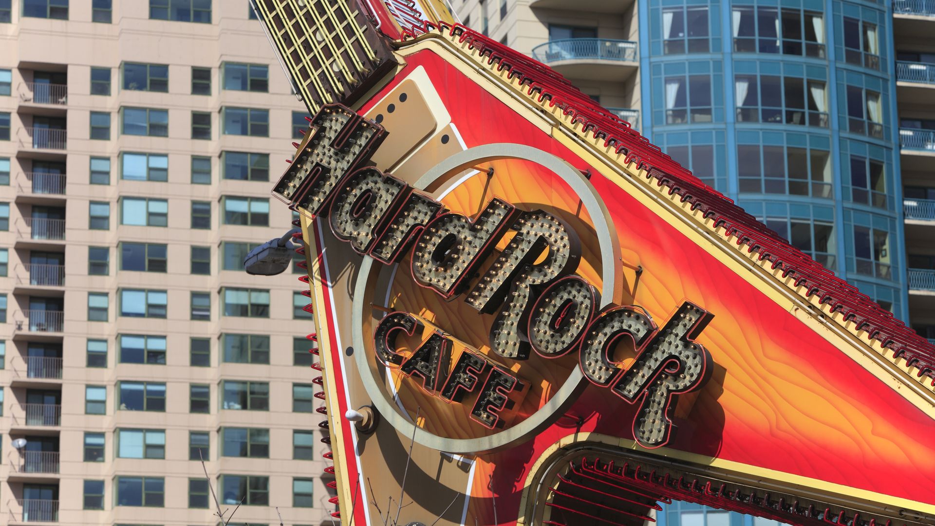 Photo of a sign that is shaped like a guitar saying "Hard Rock Cafe" 