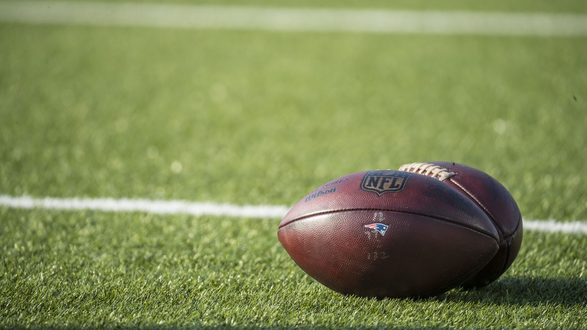 Detail view of Wilson NFL footballs bearing the New England Patriots logo.