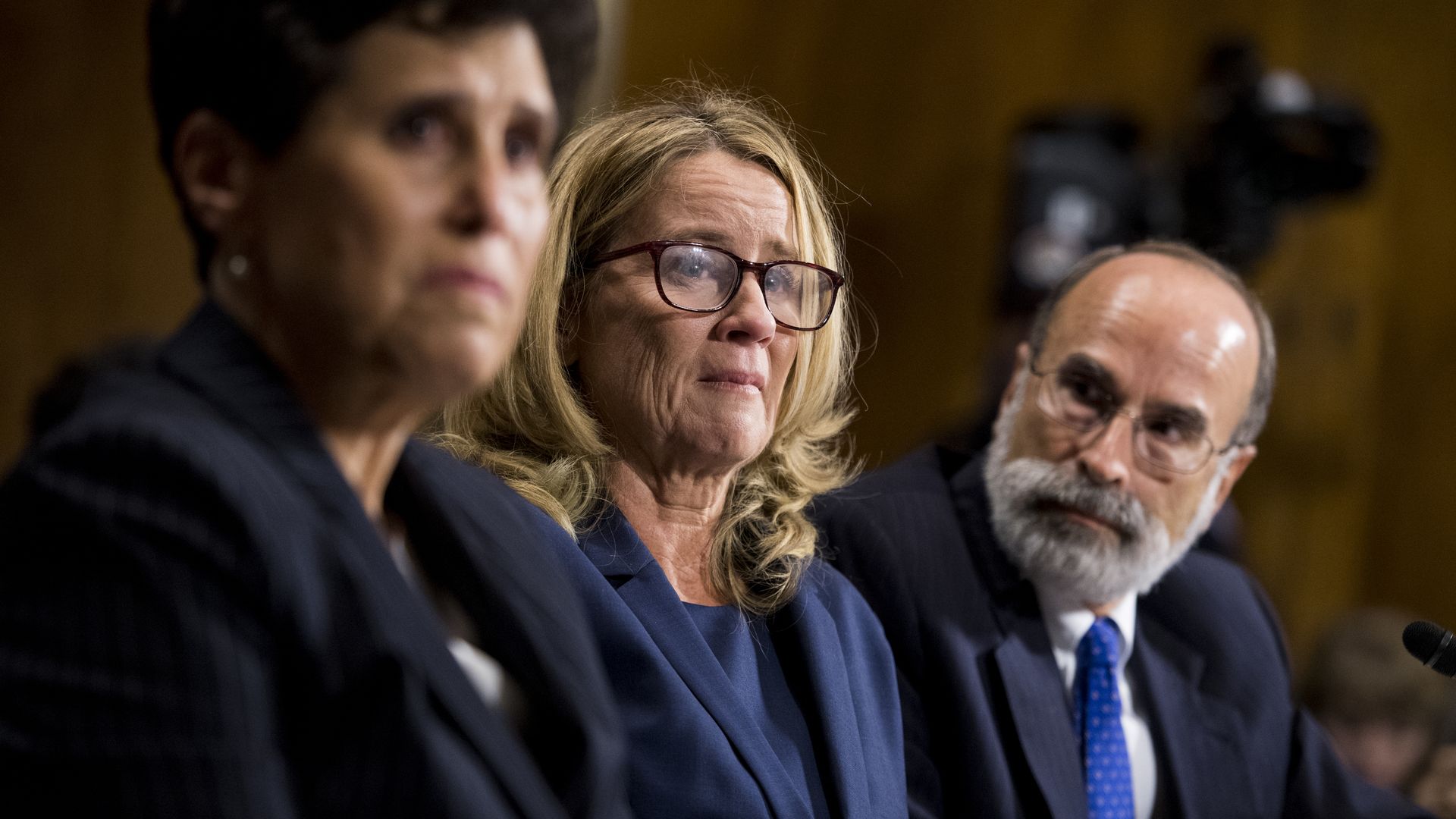 Christine BLasey Ford sits in a senate hearing next to her lawyers. 