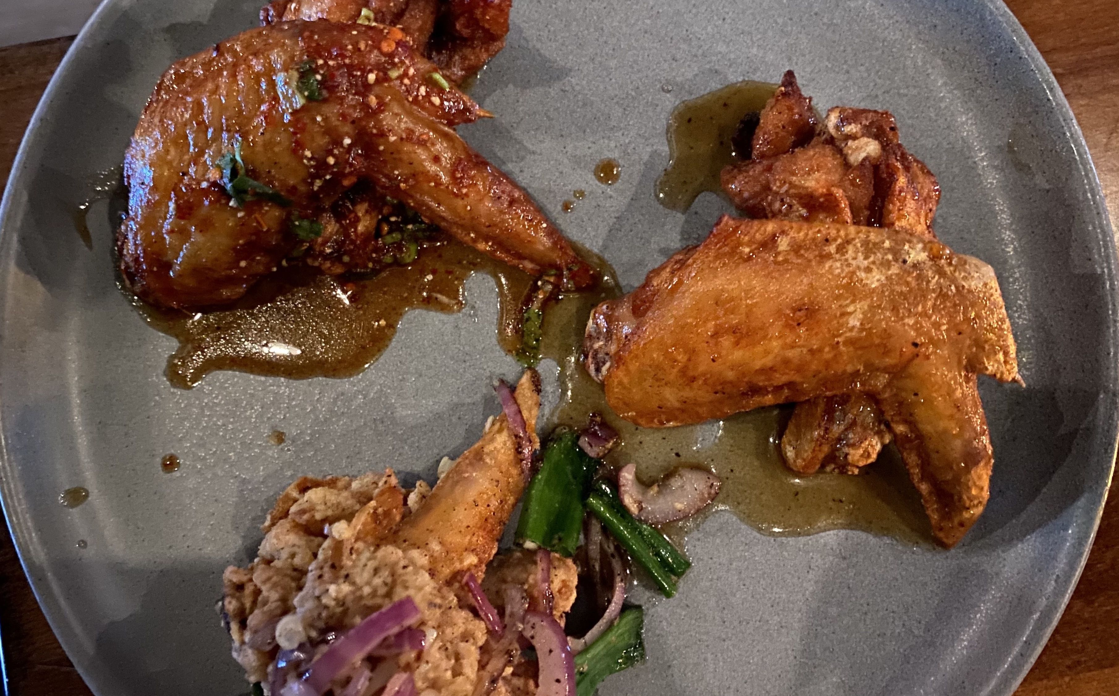 A photo of a plate of wings with elegant arrangement. 