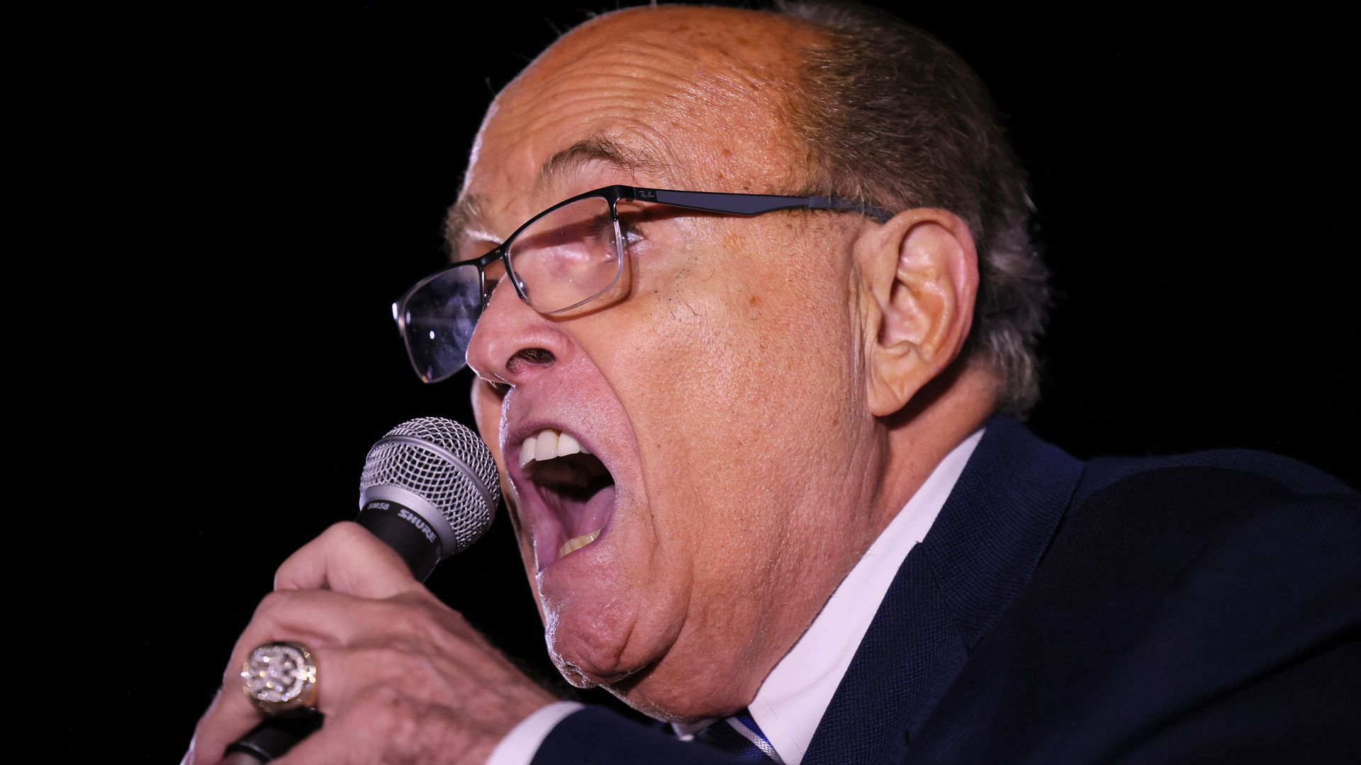 Rudy Giuliani speaks into a microphone