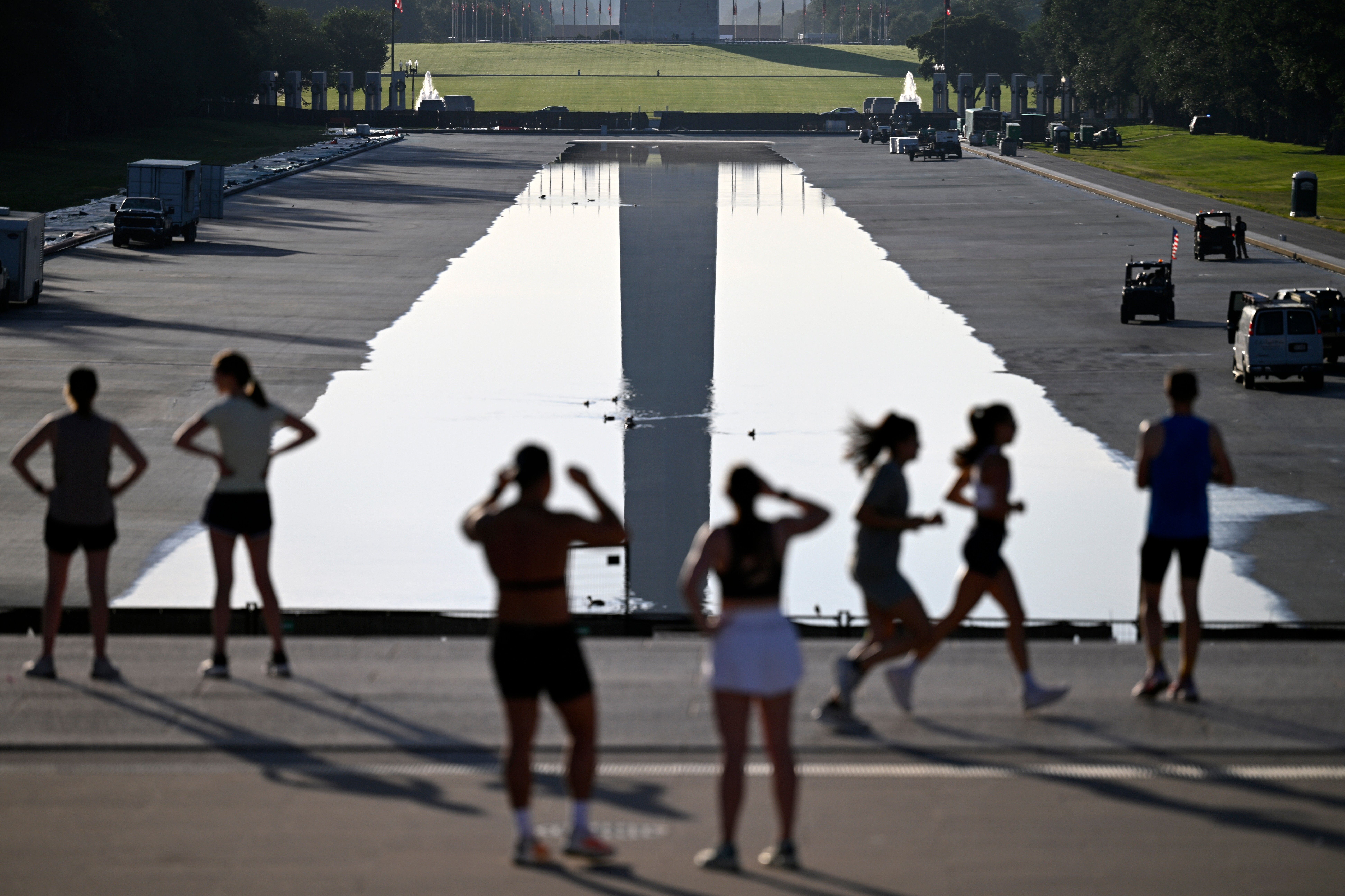 Early-morning joggers watch the refilling of the Lincoln Memorial Reflecting Pool today