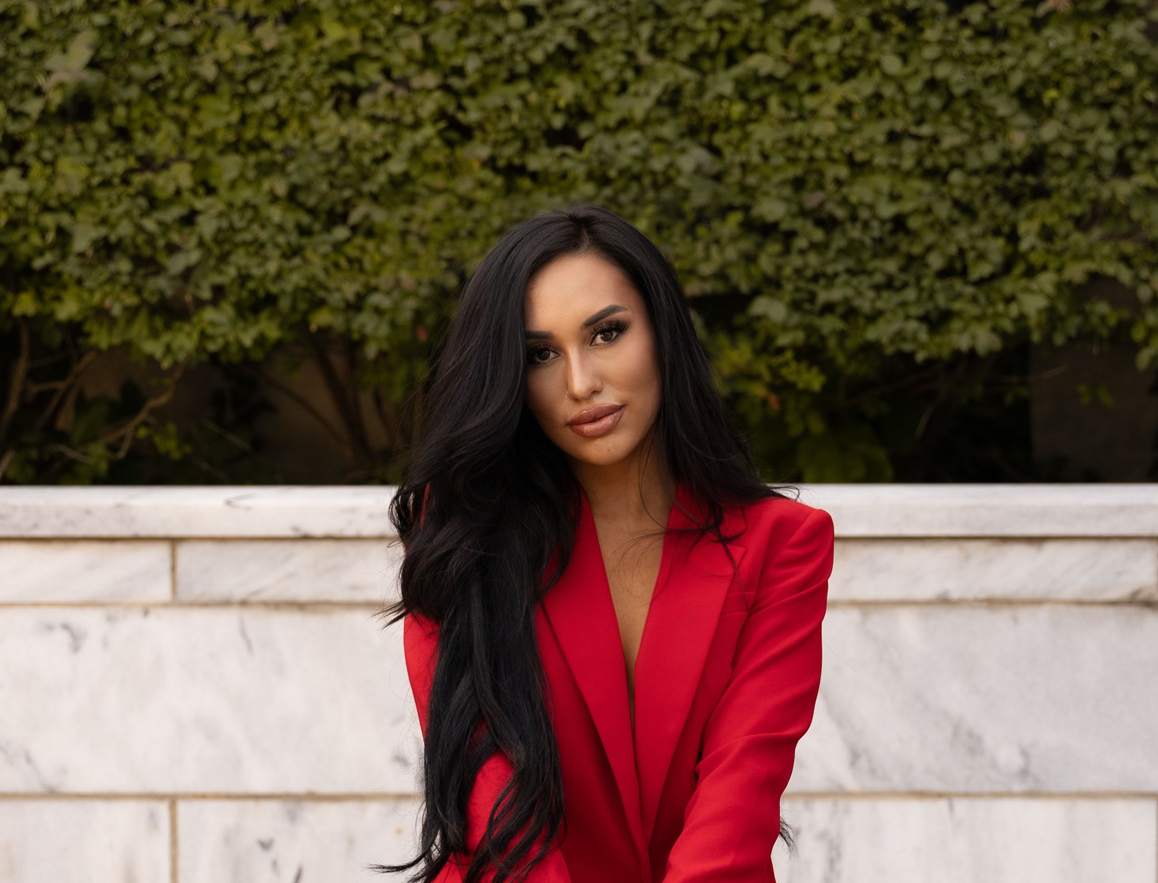 A woman poses for a photo in a red suit. 