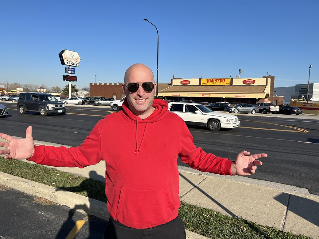 Photo of a man standing in front of a street. 