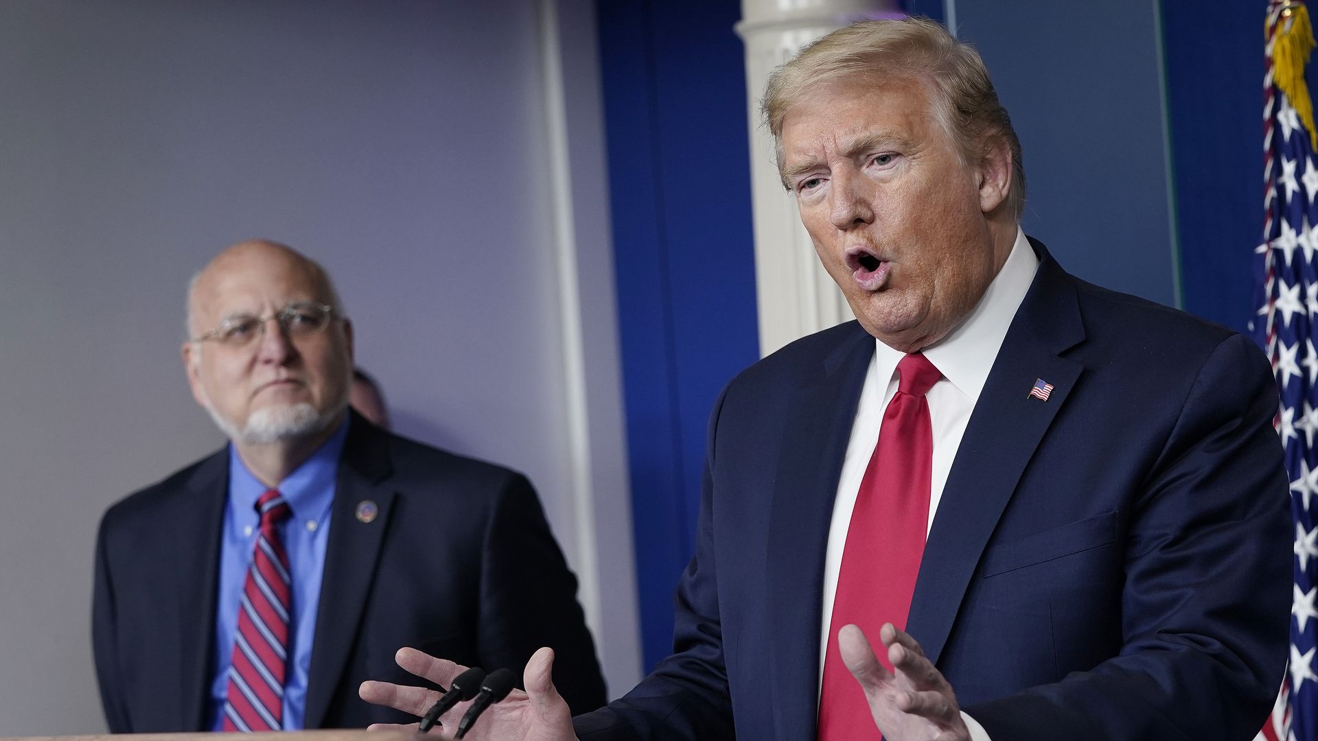 U.S. President Donald Trump speaks while flanked by Dr. Robert Redfield, Director of the Centers for Disease Control and Prevention