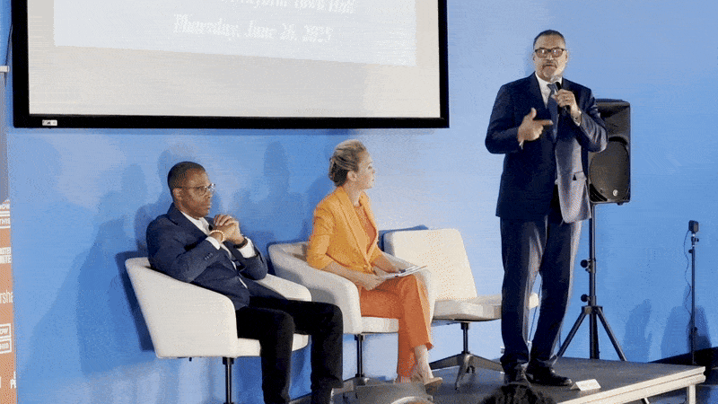 Image shows Oliver Thomas standing and talking while Arthur Hunter and Helena Moreno sit in chairs.