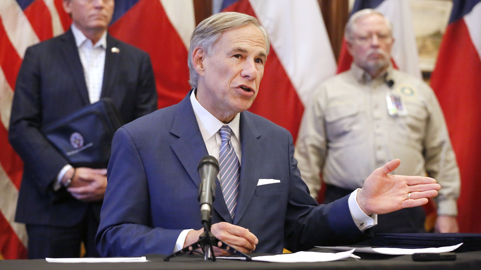 Photo of Greg Abbott speaking while raising a hand
