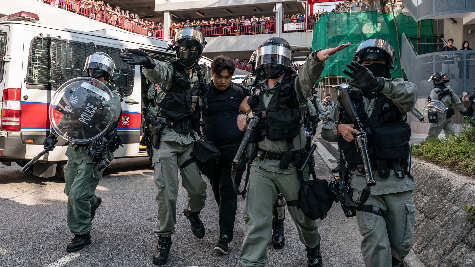 A protester is detained by riot police.