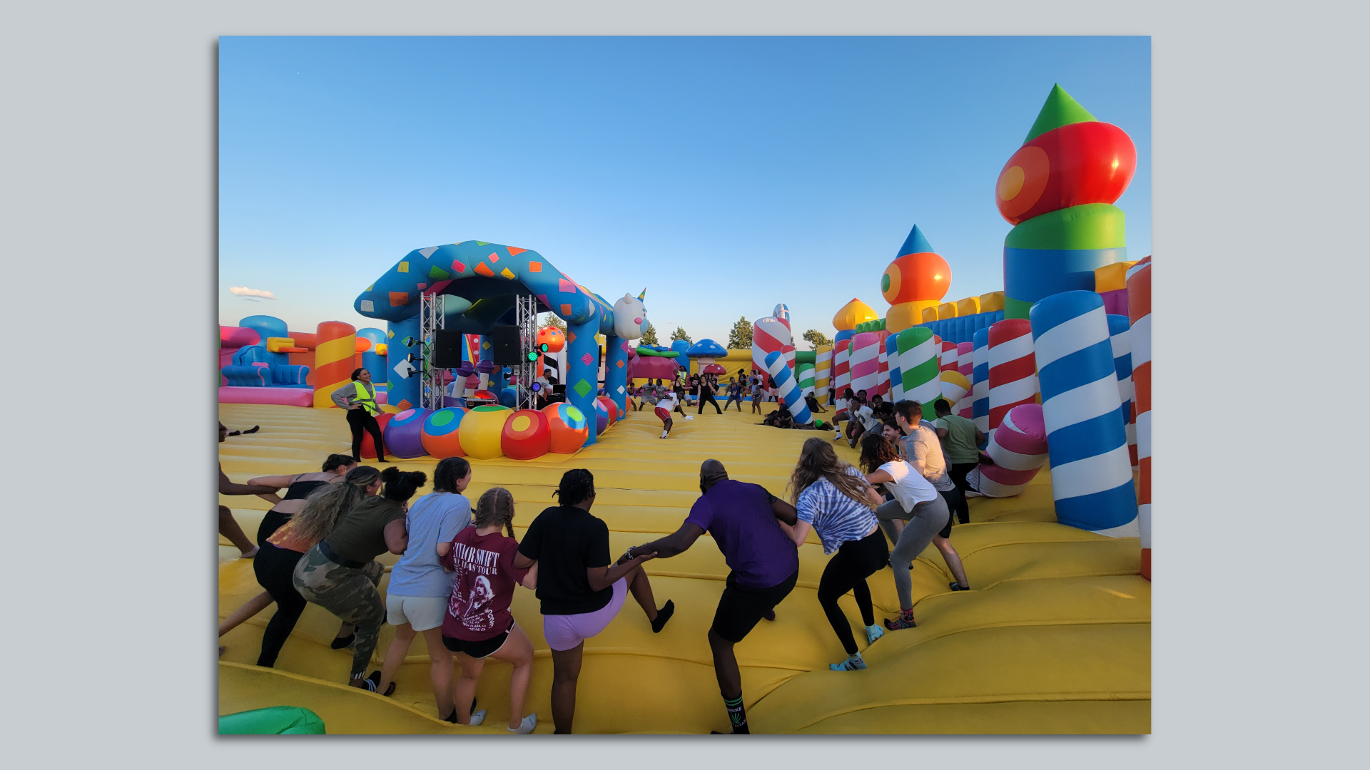 Strangers hold hands and dance inside the world's biggest bounce house in Philly. 