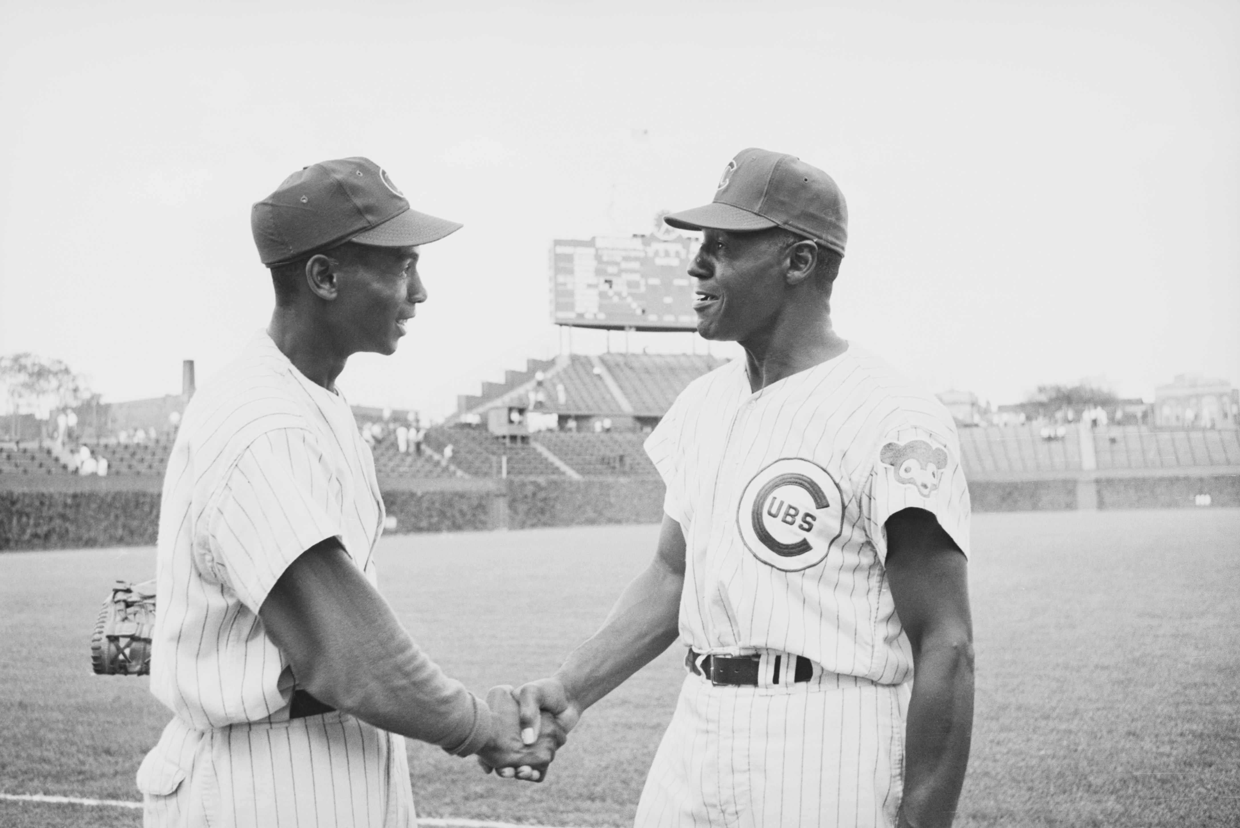 Photo of two men shaking hands while in baseball uniforms 