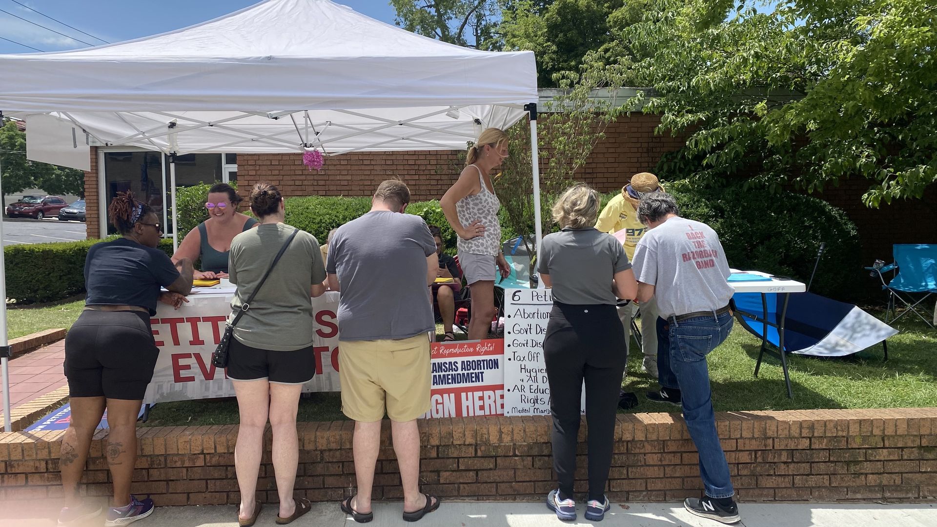 Voters line up to sign petitions for Arkansas' various citizen initiated ballot proposals on July 4, 2024.