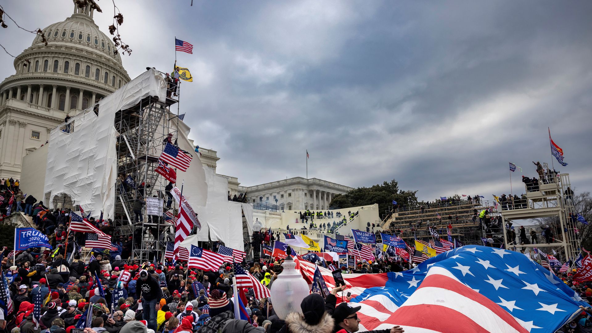 Photo of the Jan. 6 Capitol insurrection. Rioters are outside the Capitol with American flags.