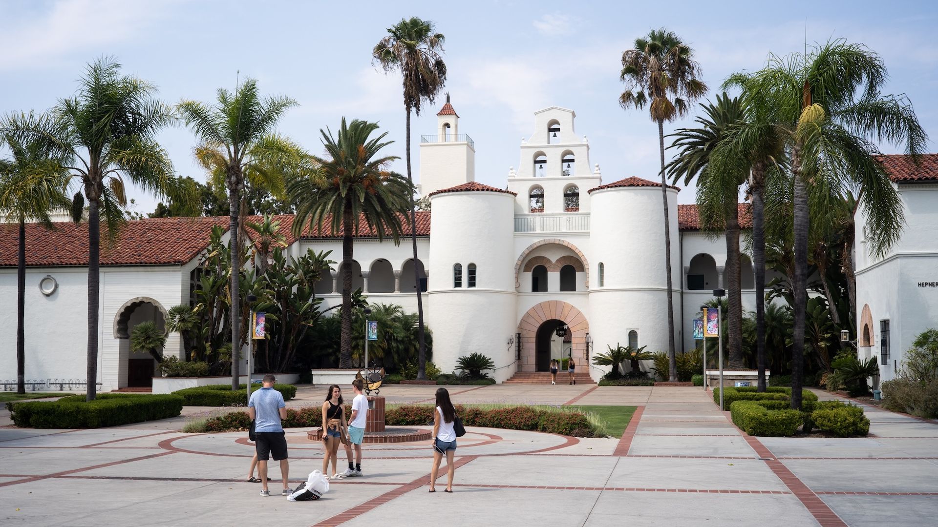 Students stand outside a building at San Diego State Univeristy.