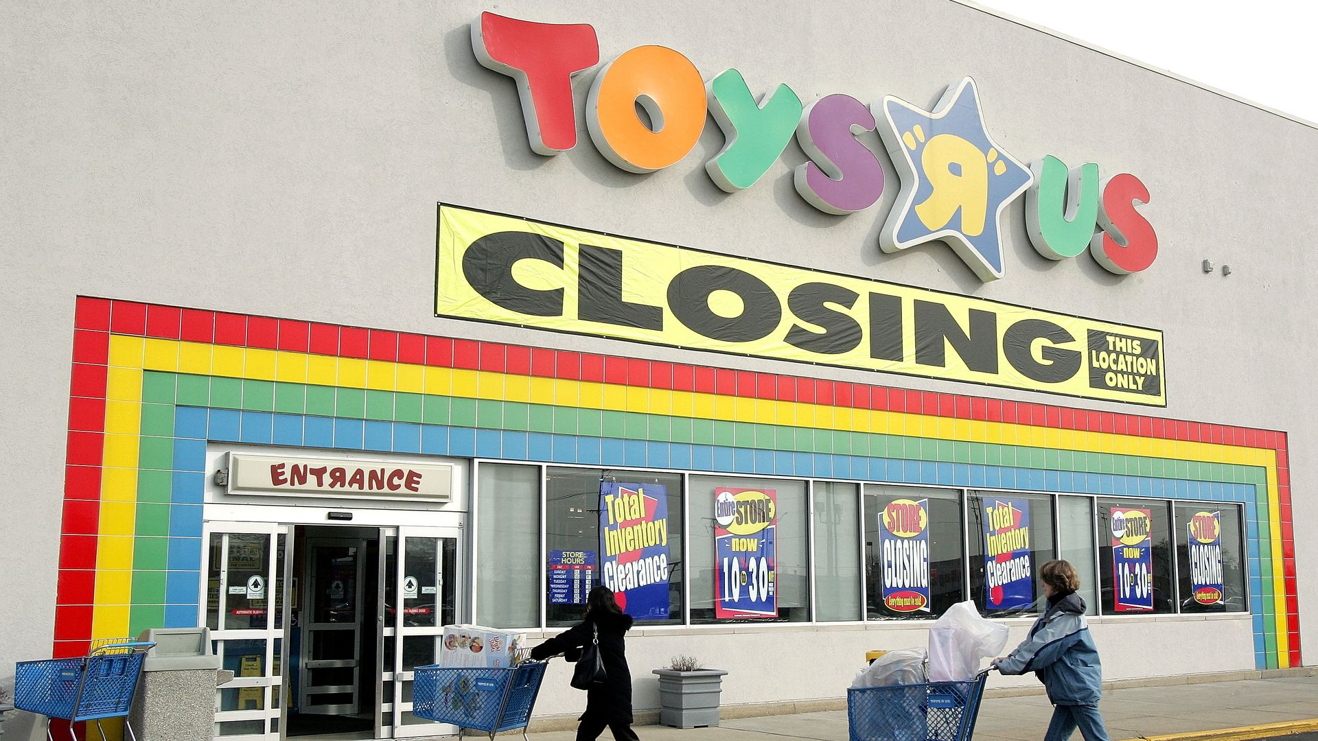 A storefront with the store name Toys R Us spelled out in giant letters in different colors above the entrance.
