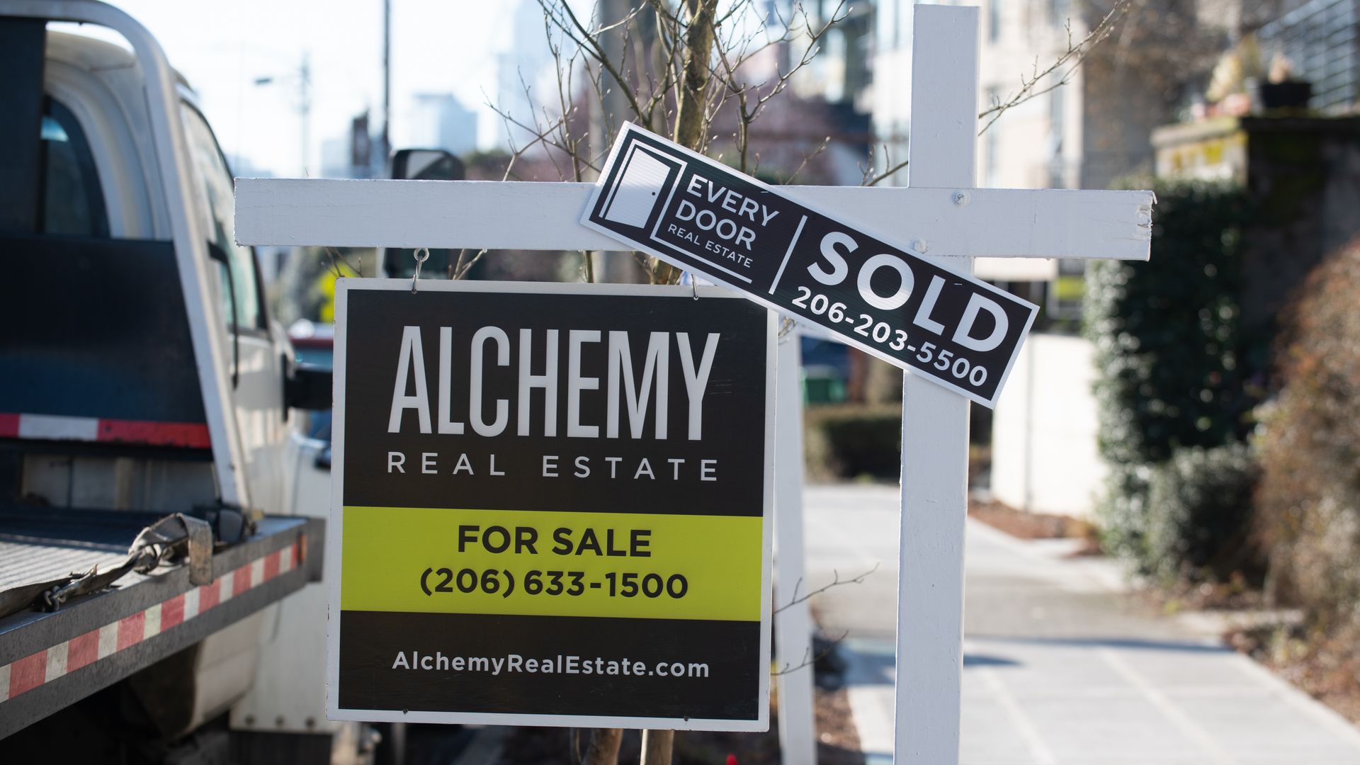 A "sold" sign tops a "for sale" sign outside a Seattle home.
