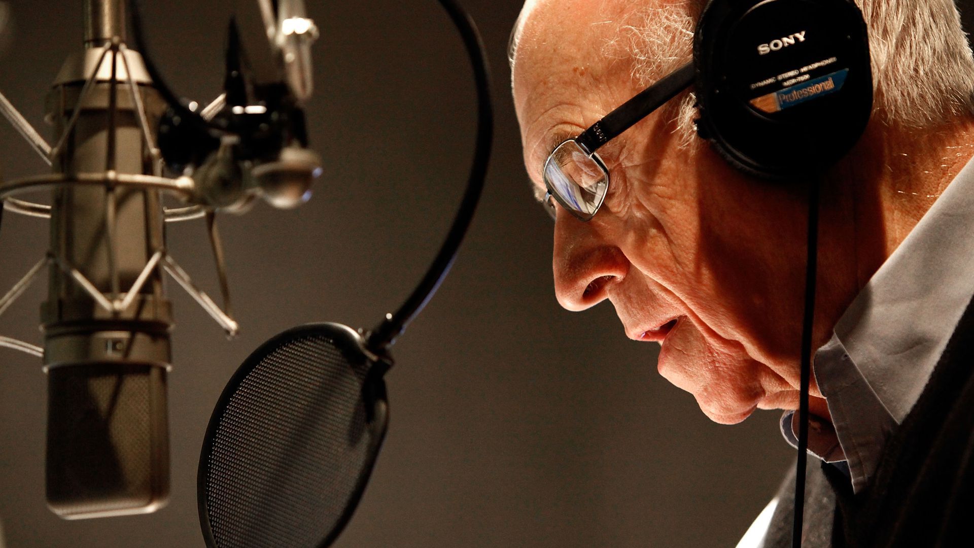 Photo of a man speaking into a microphone