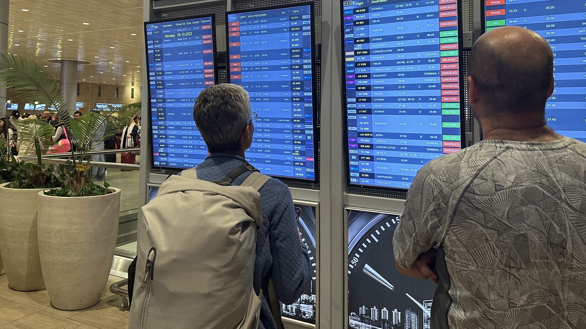 People looking at flight information at Ben Gurion Airport in Tel Aviv on Oct. 8.