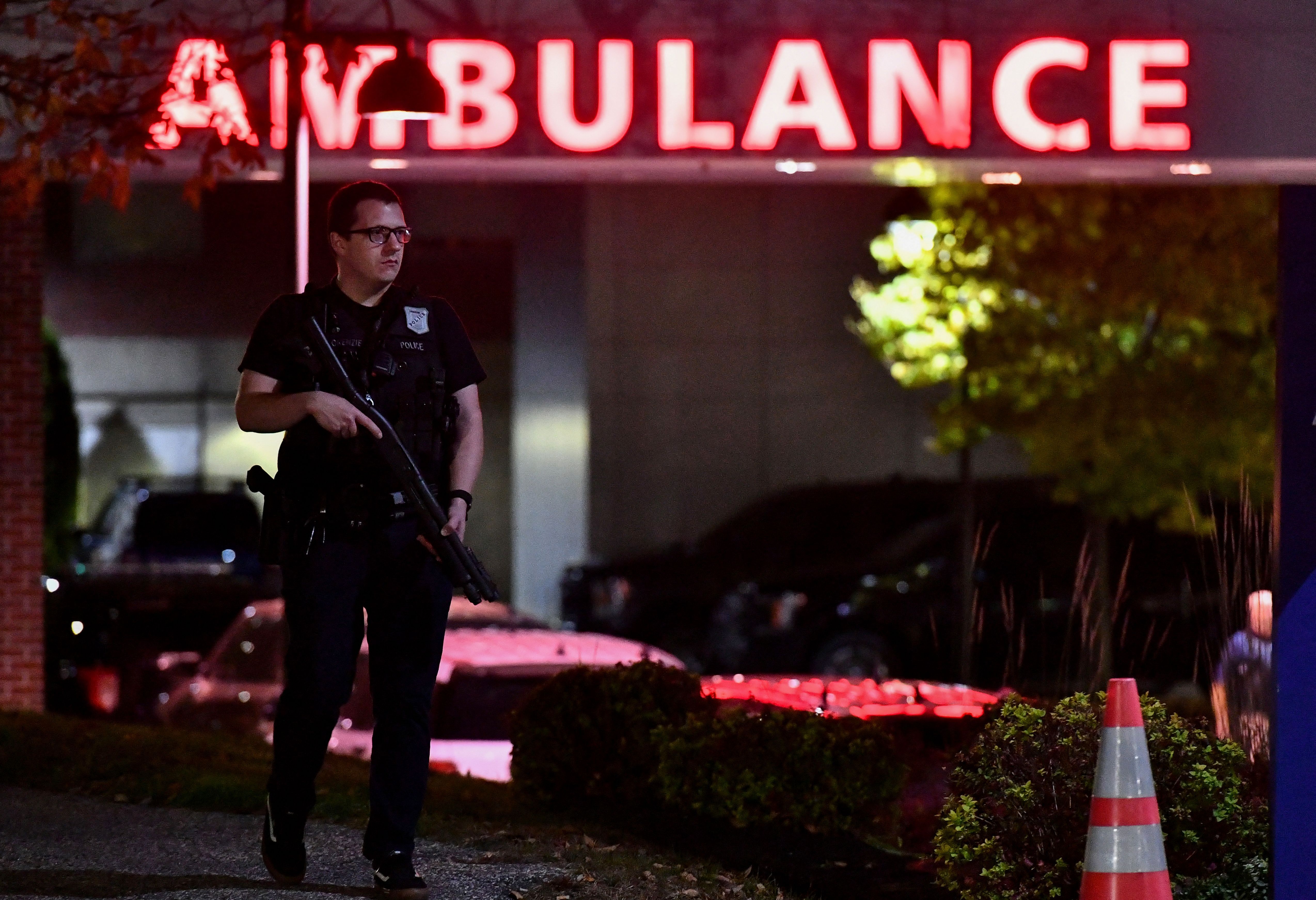 An armed police officer guards the ambulance entrance to the Central Maine Medical Center in Lewiston, Maine, early on Thursday. 