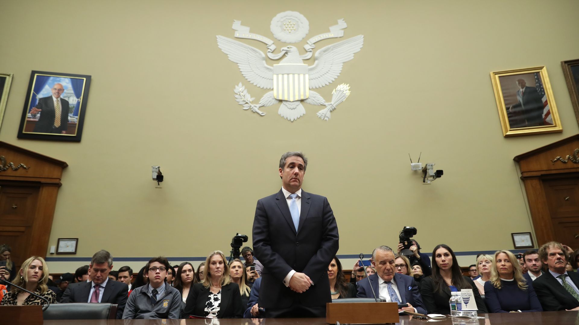 In this image, Michael Cohen stands with his hands folded in court and looks down. 