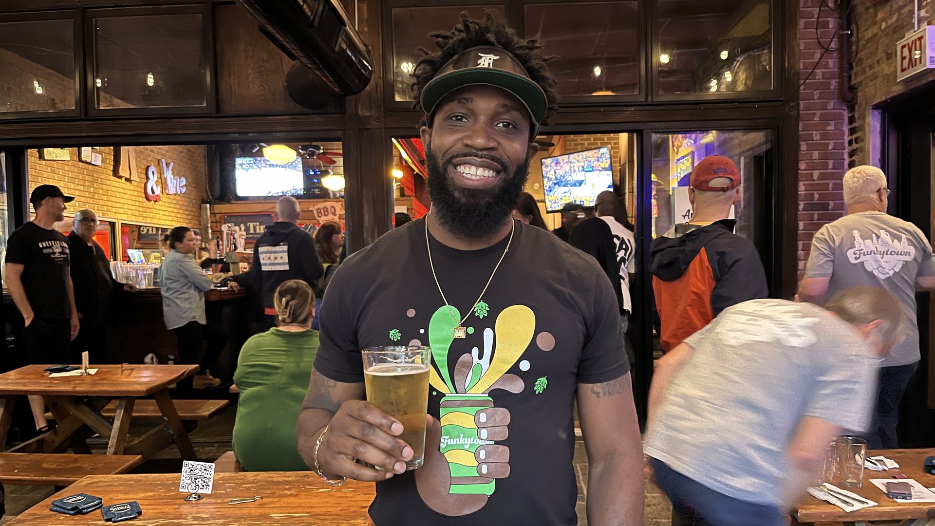 Photo of a man holding a beer at a bar 