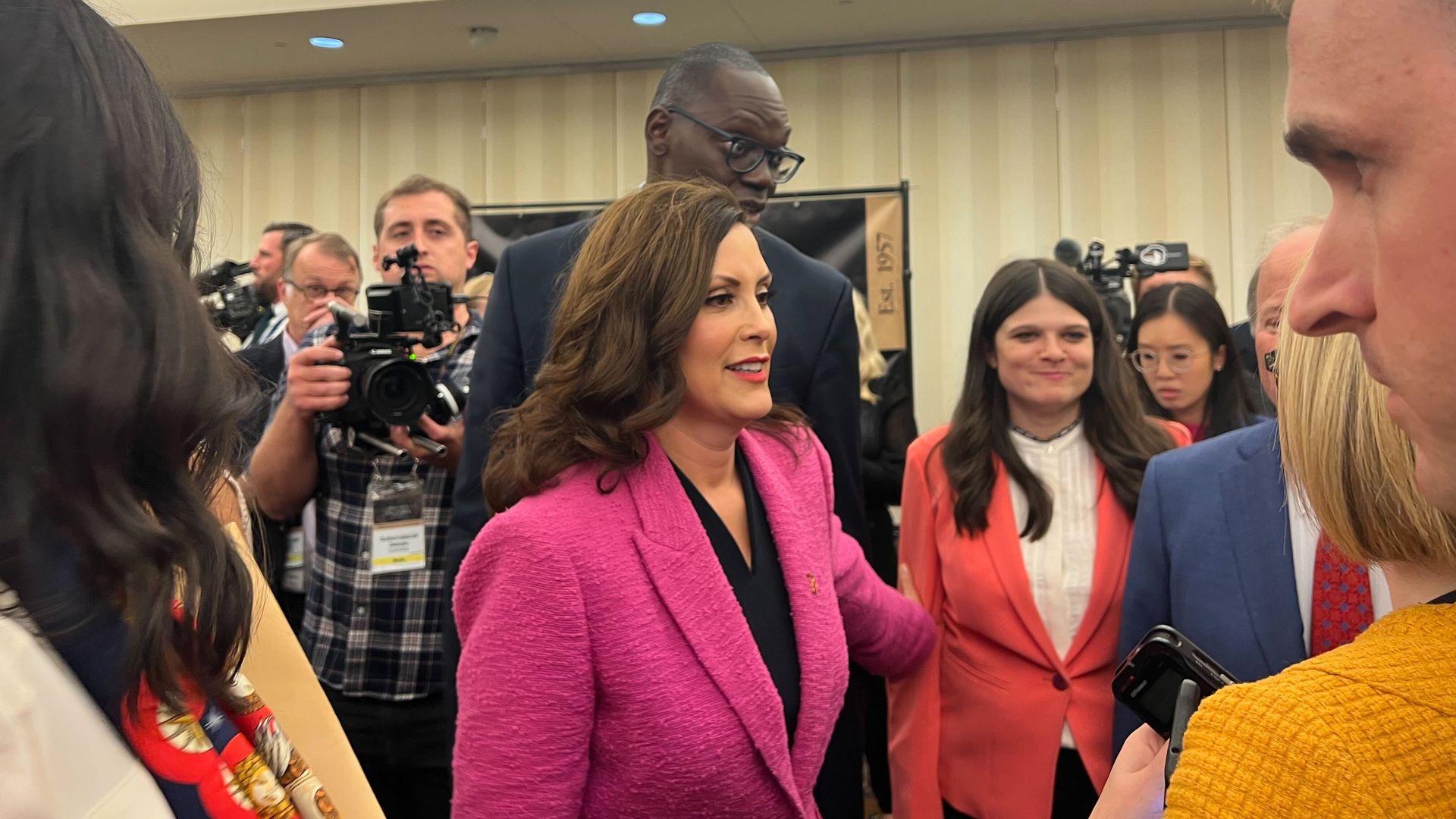 Gov. Whitmer stands in front of Lt. Gov. Garlin Gilchrist and US Rep. Haley Stevens