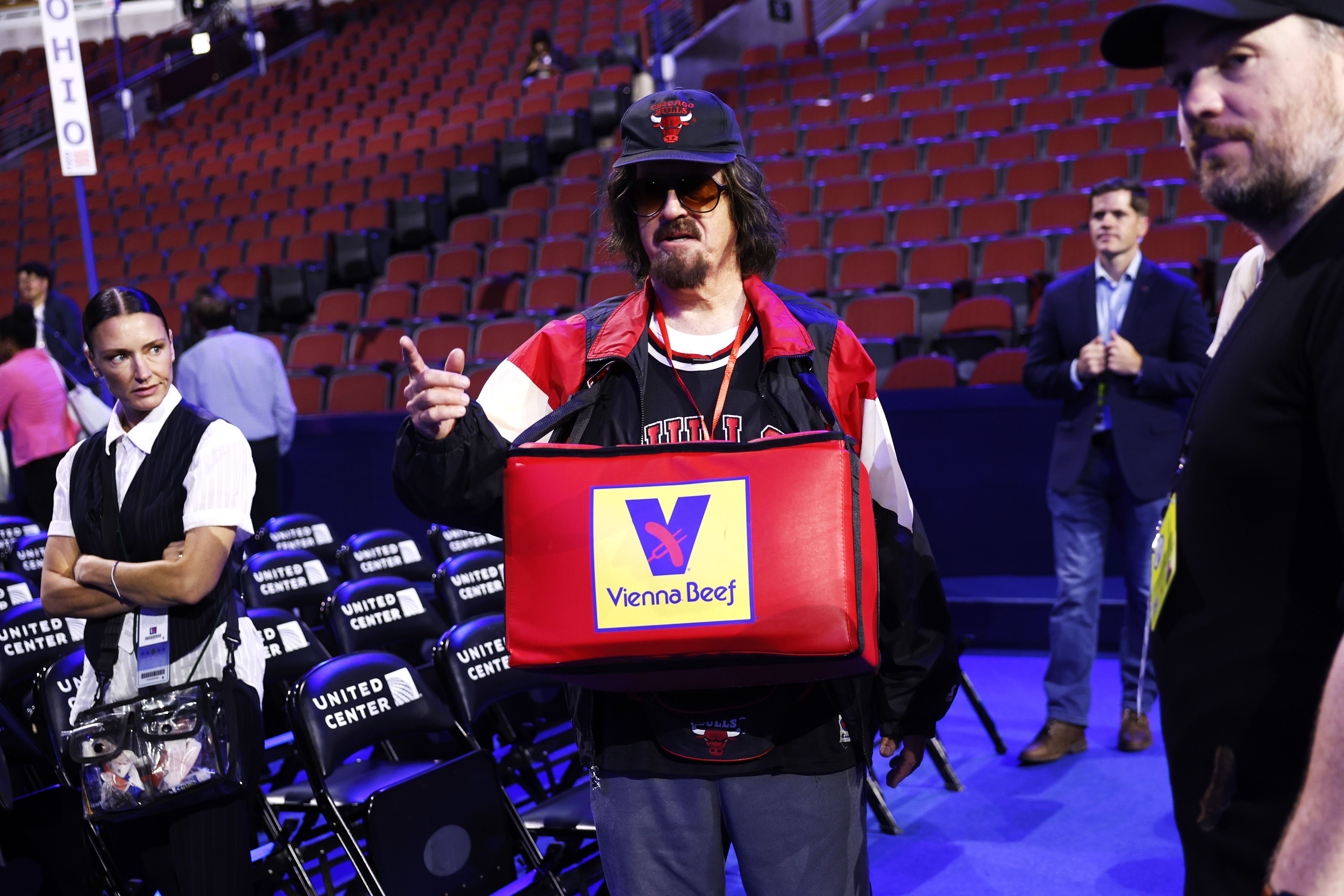 Stephen Colbert carries a container of Vienna Beef hot dogs in United Center on Sunday.