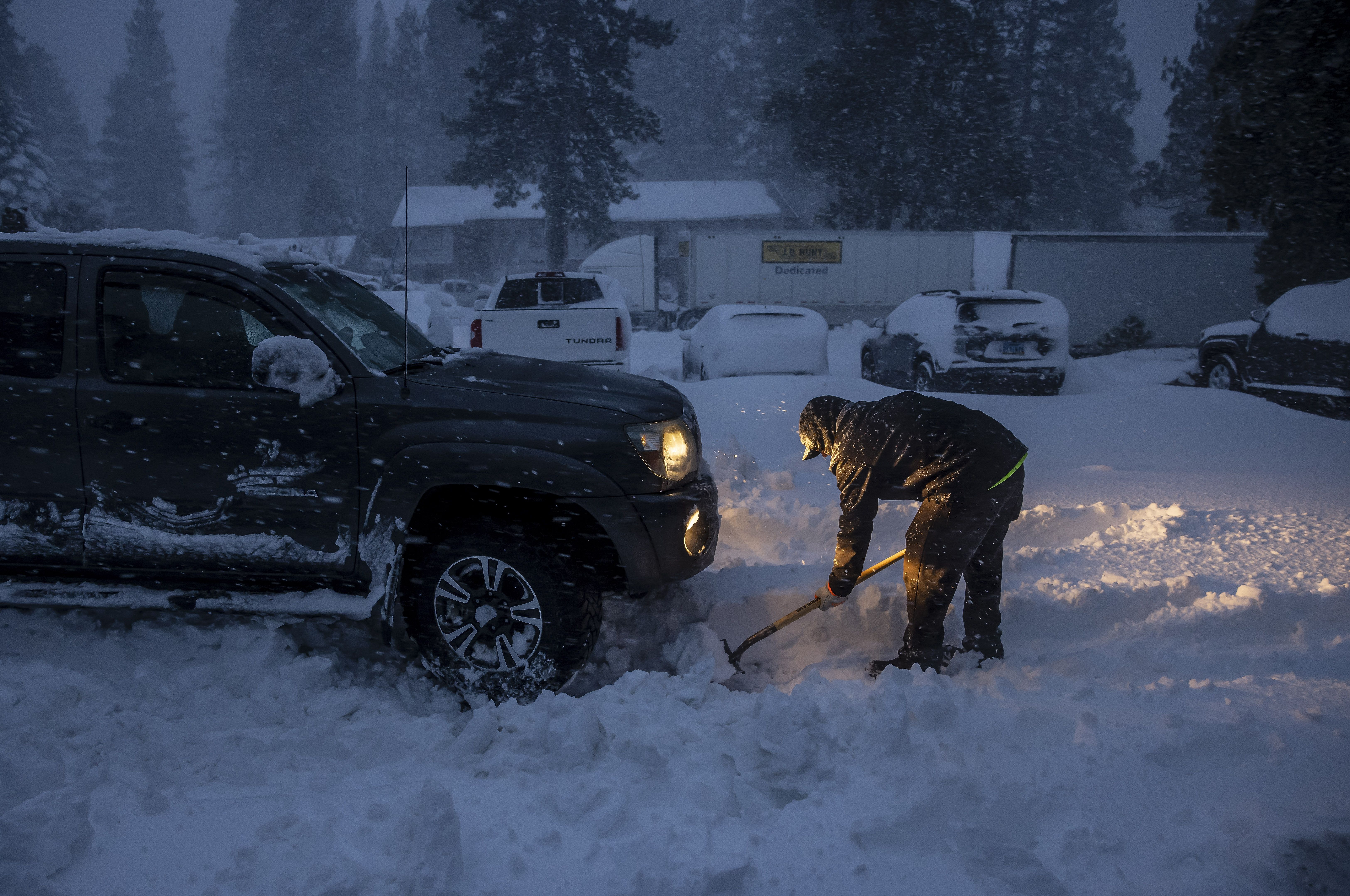 Daniel Sandoval tries to dig out his truck that got stuck in snow after dropping off his daughter at work in Weed, Calif., on Wednesday, November 20, 2024. 