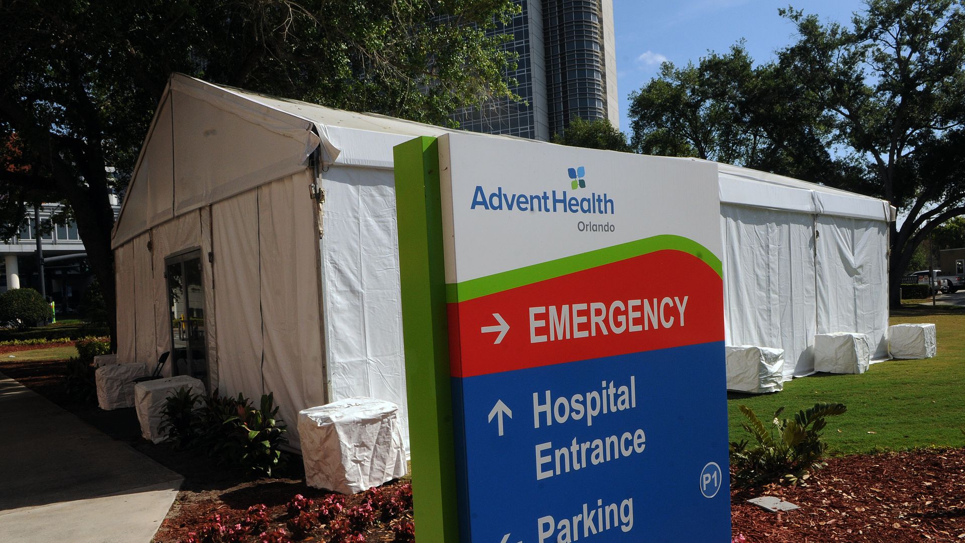 A white pop-up tent in front of an AdventHealth hospital emergency department sign.