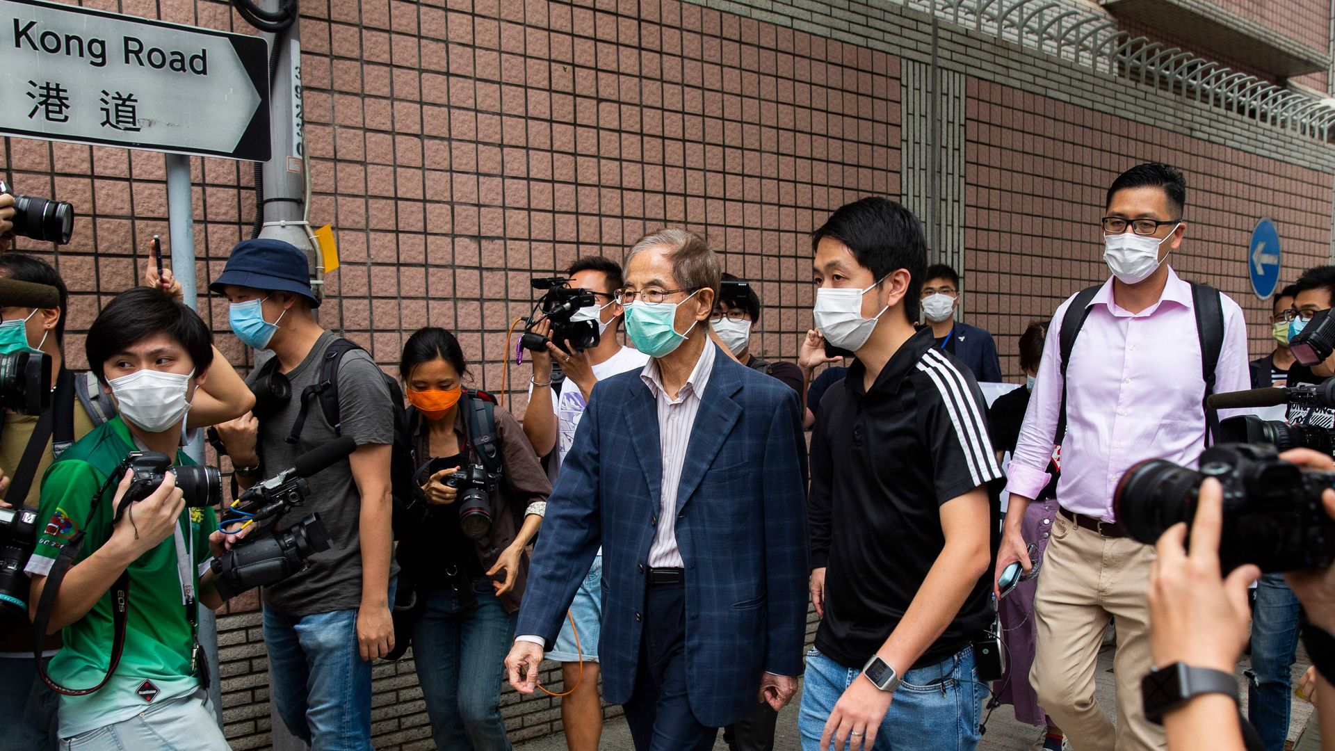 Former lawmaker and pro-democracy activist Martin Lee (C) leaves the Central District police station in Hong Kong