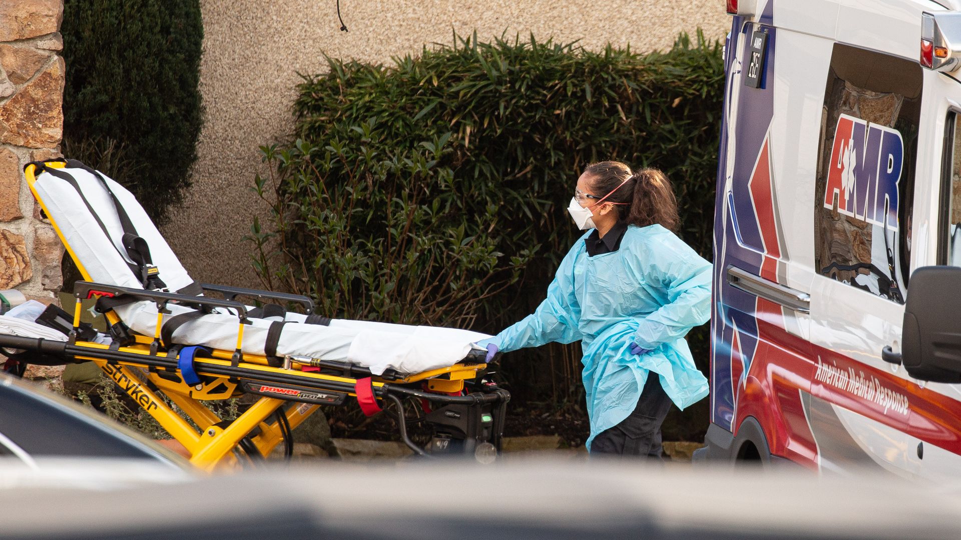 A health care worker prepares to transport a patient into an ambulance in Kirkland, Washington.