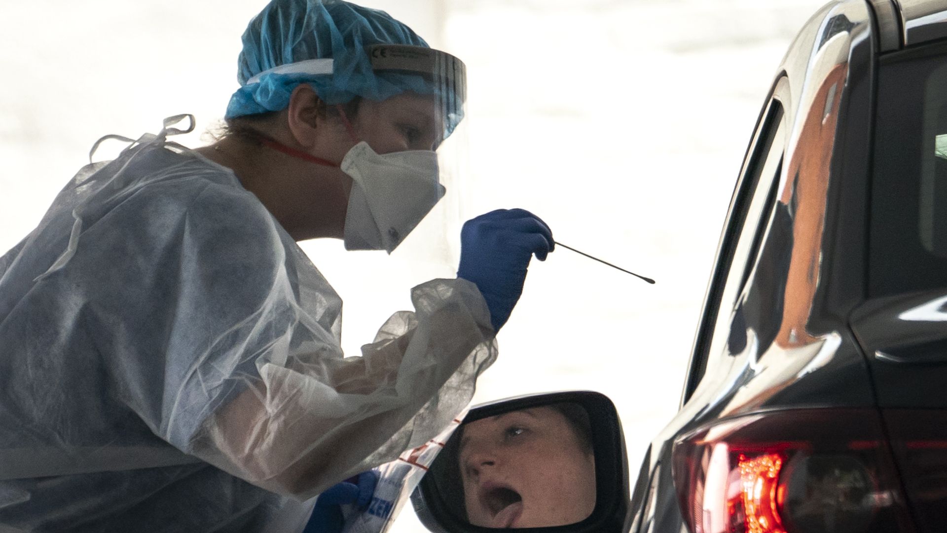A photo of a health care worker administering a coronavirus test. 