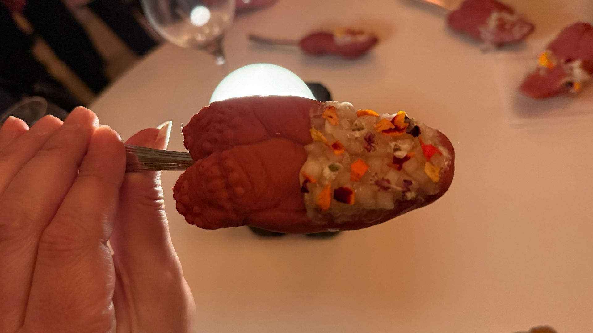 Photo of a rubber tongue with a stem being held by someone's hand