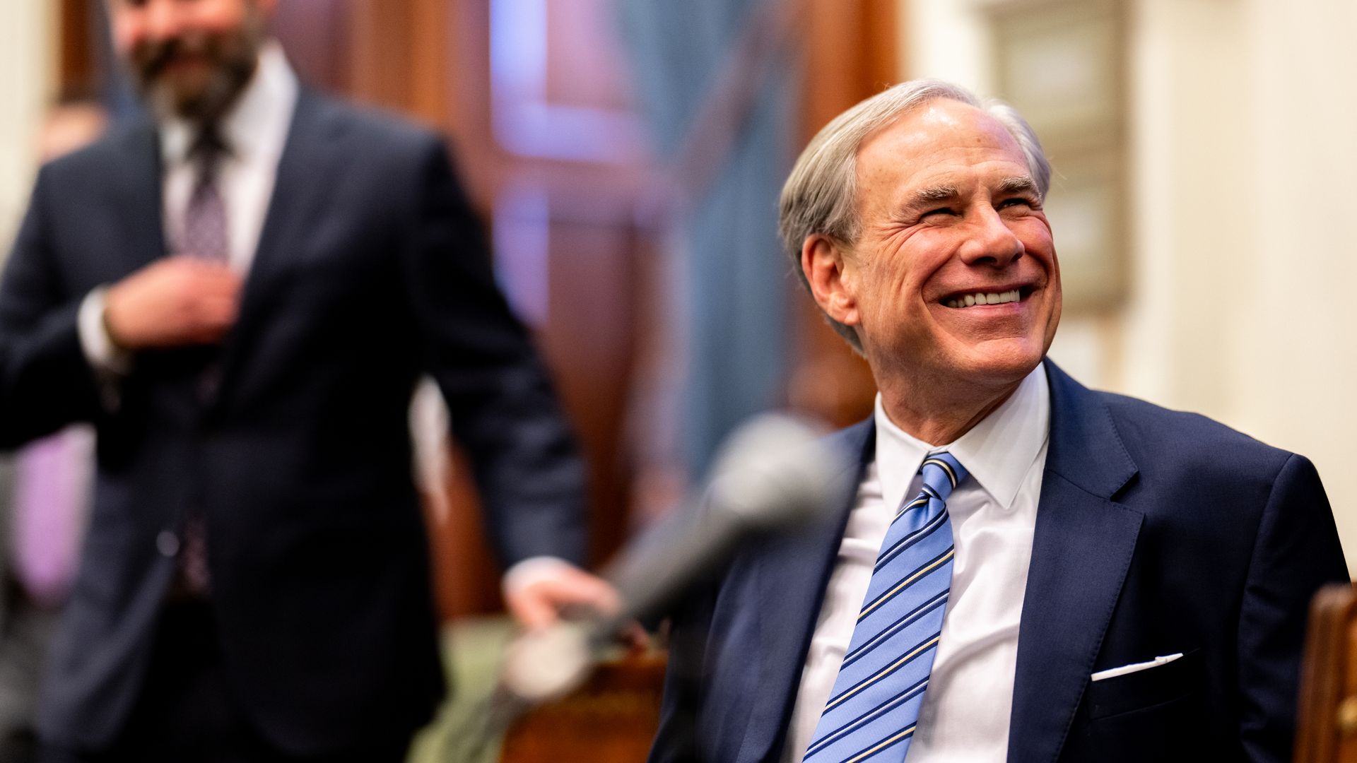 Greg Abbott smiles and looks to his left 