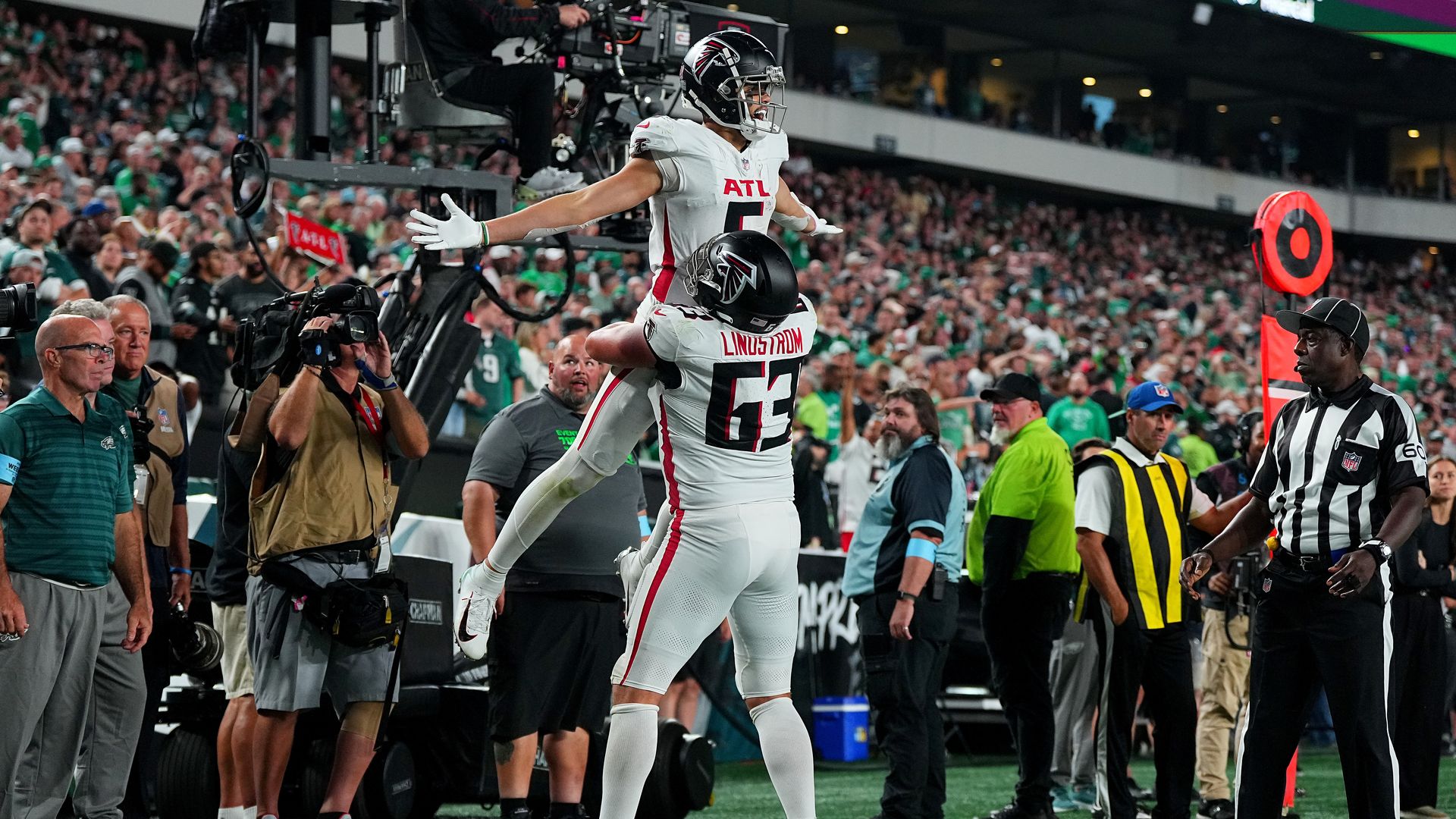 Two men in white football uniforms celebrate during a game