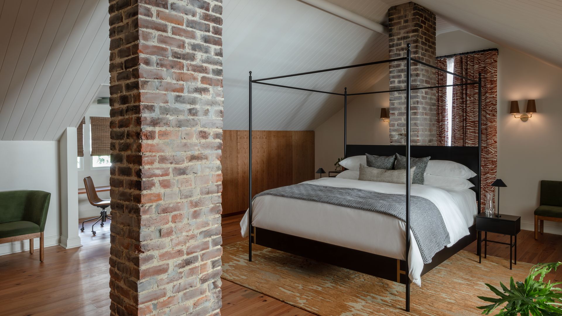 A four-poster bed sits between brick columns.