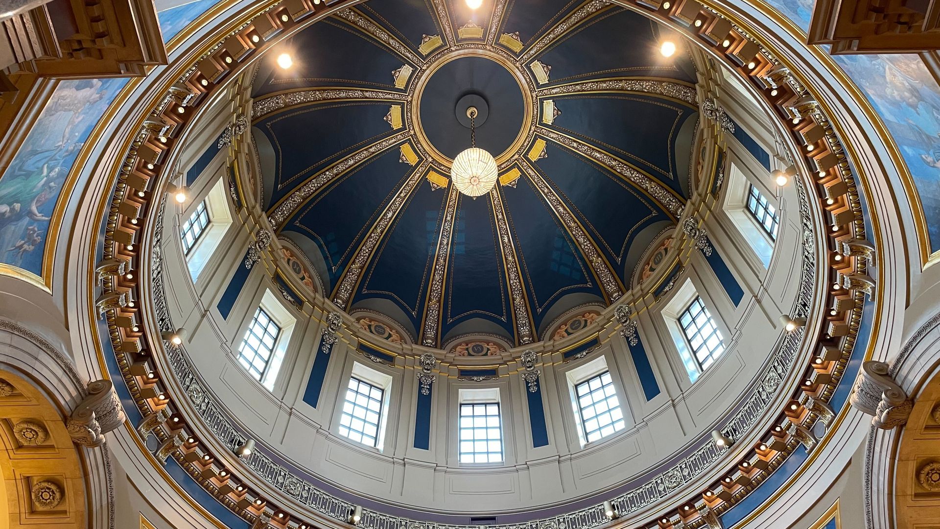 A circular ceiling with windows and blue colors
