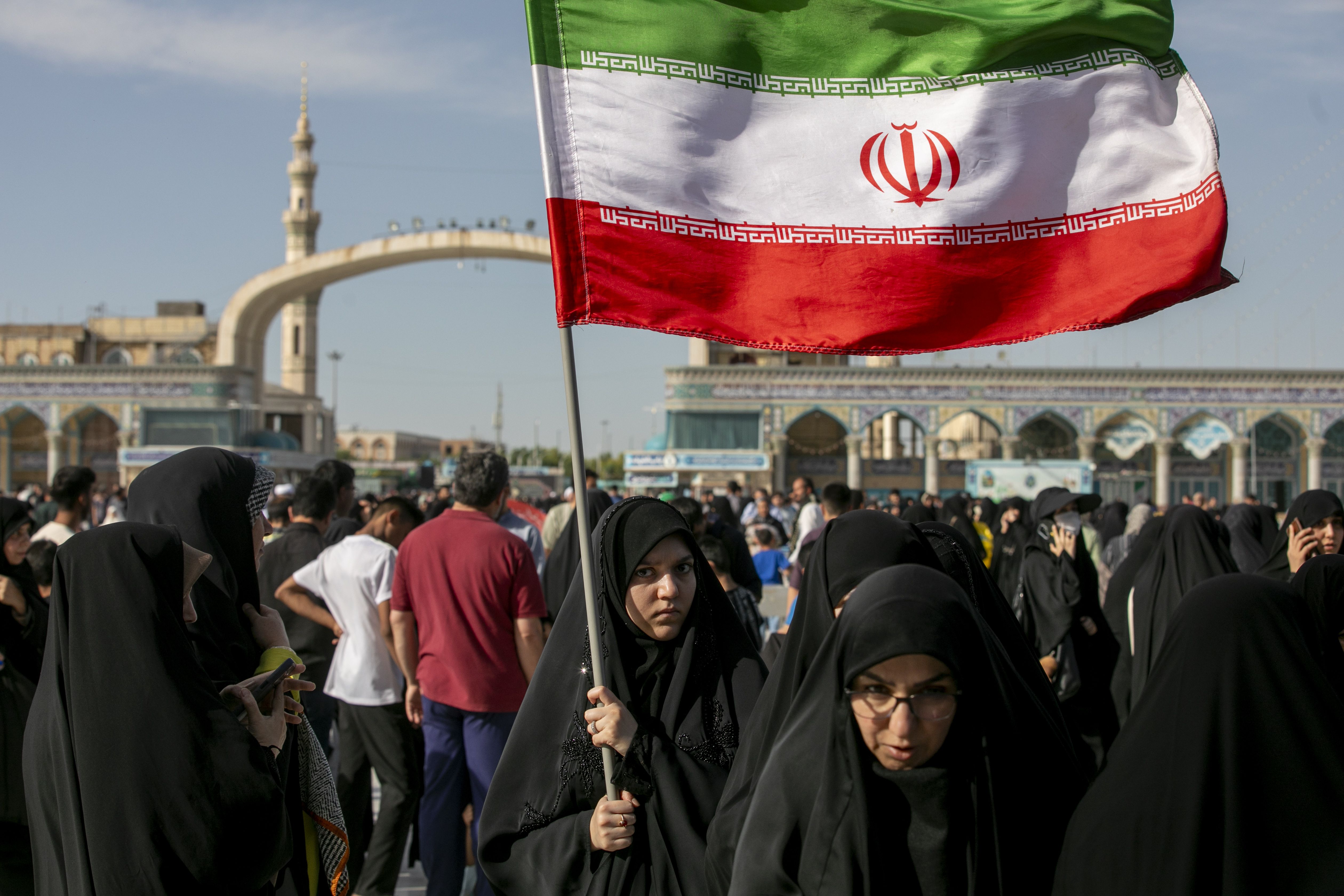 A woman is seen carrying an Iranian flag during Eid al-Adha on May 26, 2026 in Qom, Iran.
