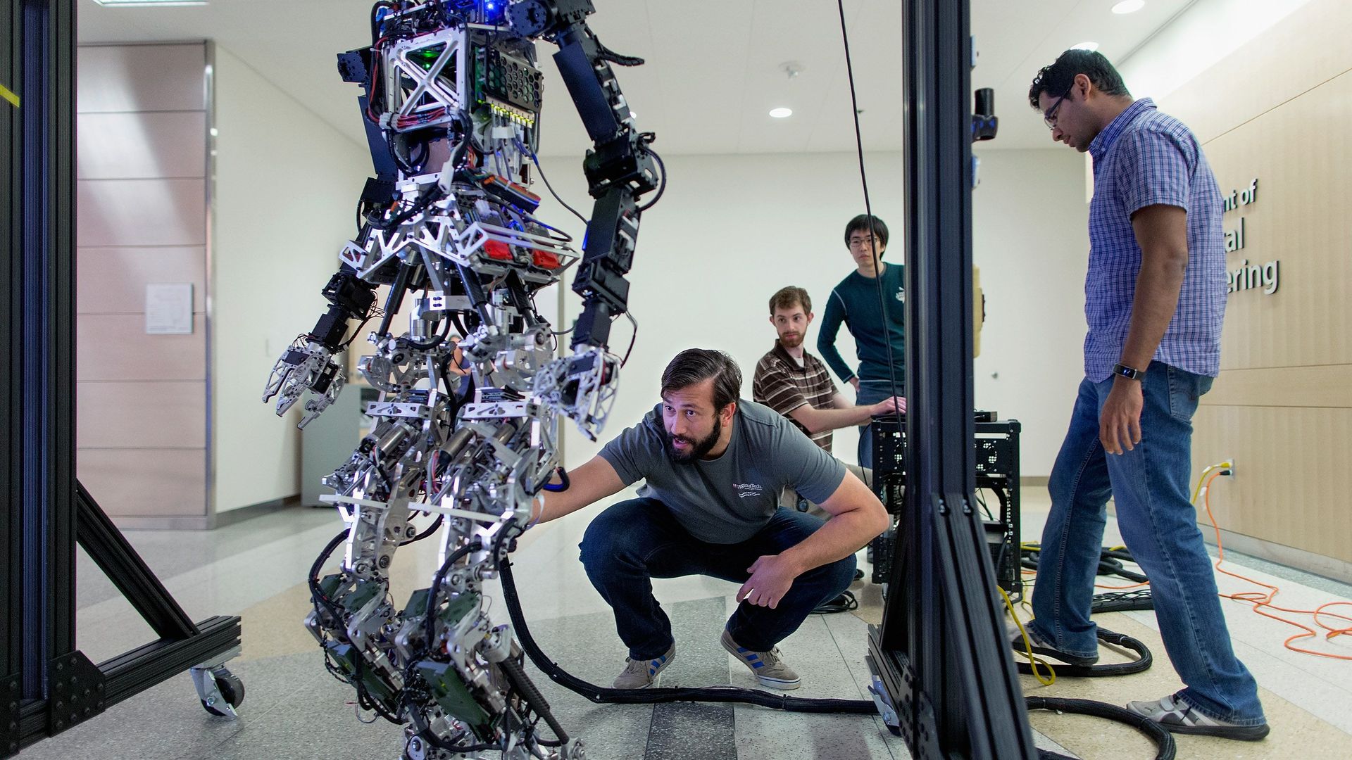 Photo of people adjusting a robot