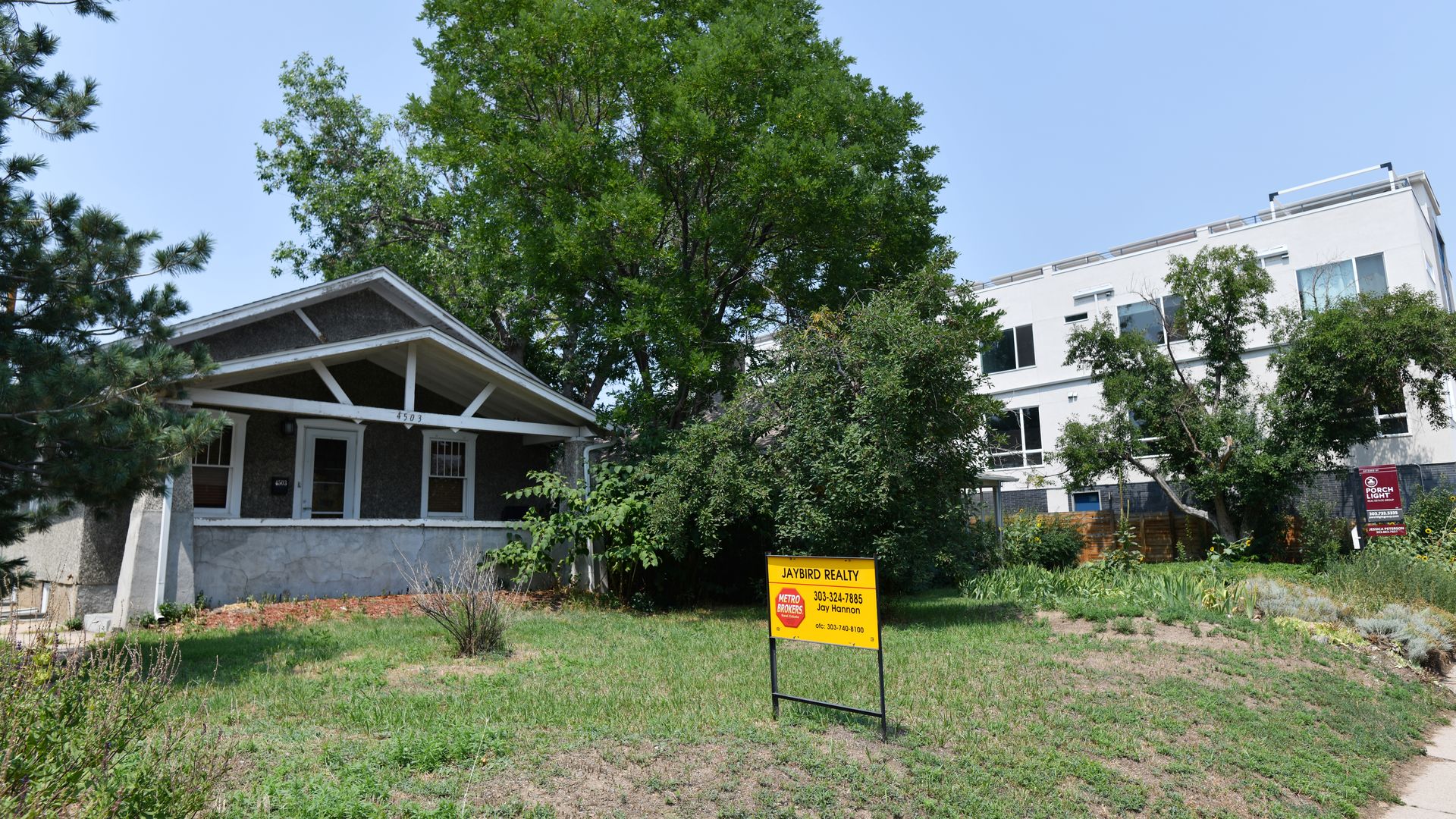 Two for-sale bungalows next to a high-rise housing development on Tennyson Street in August 2021. Photo: Hyoung Chang/Denver Post via Getty Images