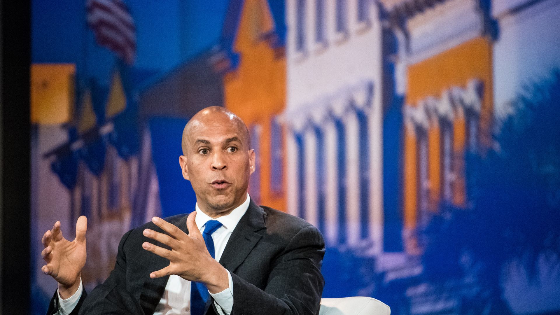 In this image, Booker sits while speaking.