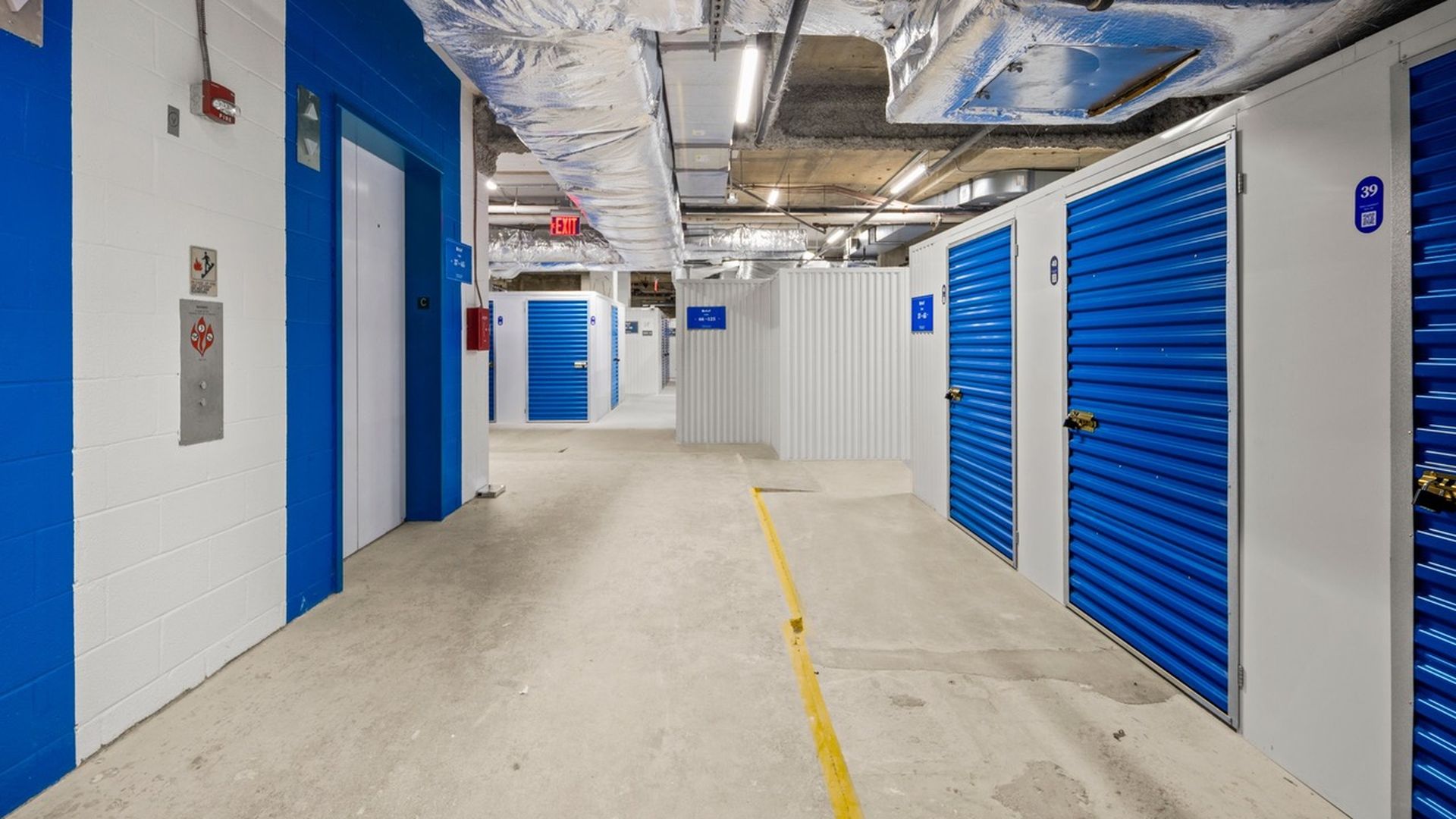 Blue and white metal storage units installed in unused basement space.