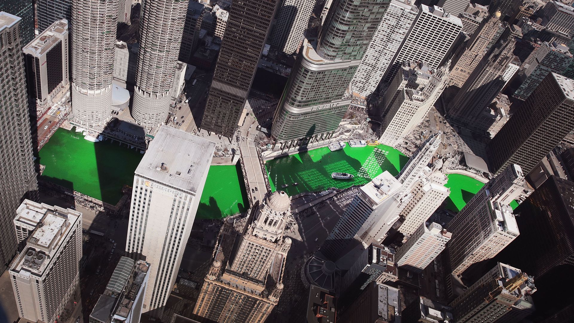Photo of tall buildings and a green river. 