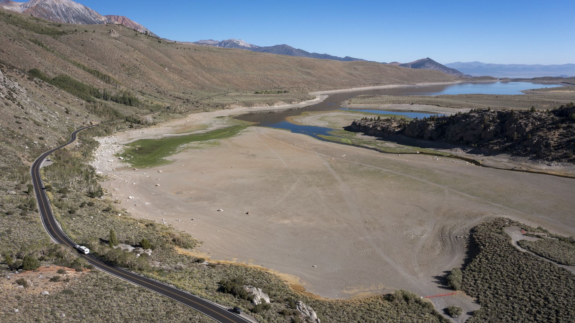 In an aerial view very low water level exposes an expanded shoreline at Grant Lake, which is fed by now-nearly snowless mountains in the Eastern Sierra Nevada, on August 11.