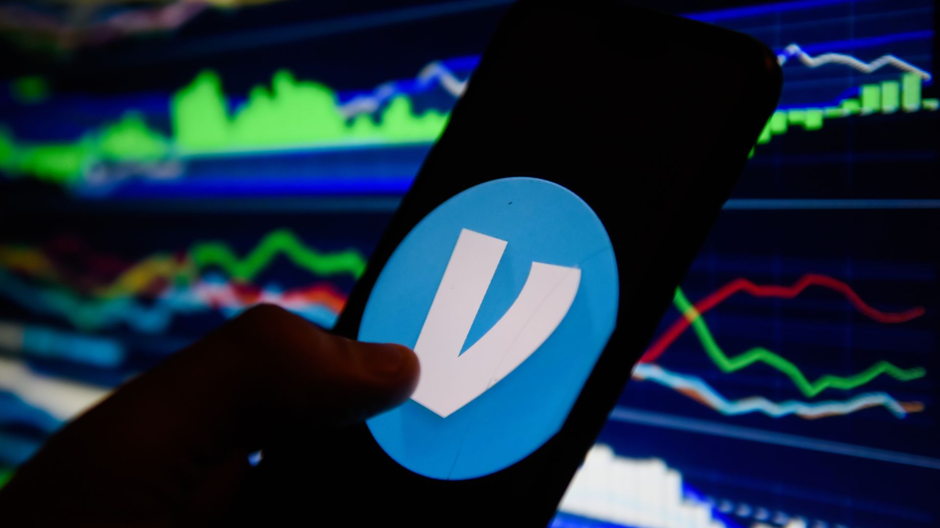 In this image, someone holds a smartphone with the Venmo logo displayed