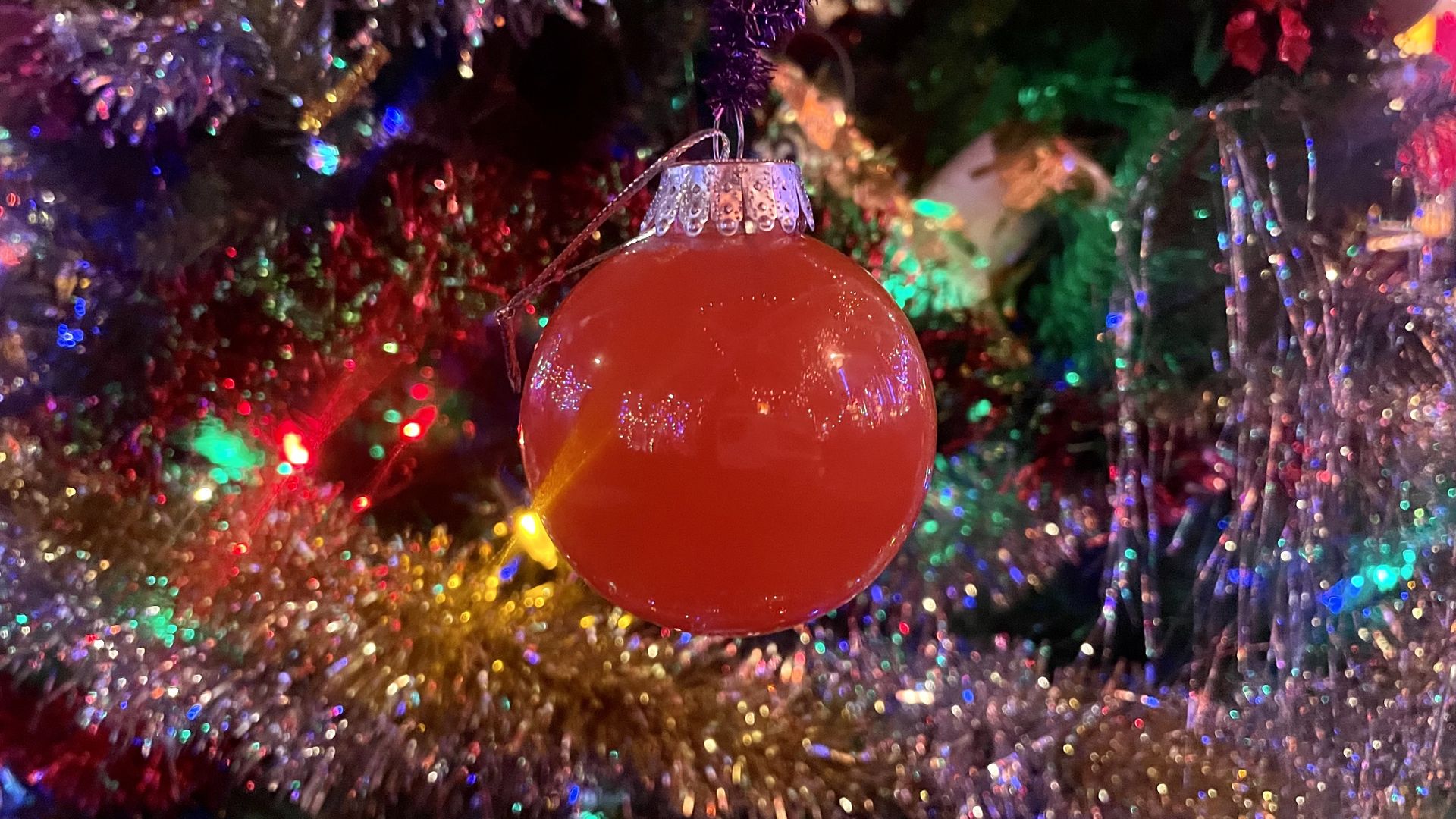 A clear plastic ornament filled with a red liquid.