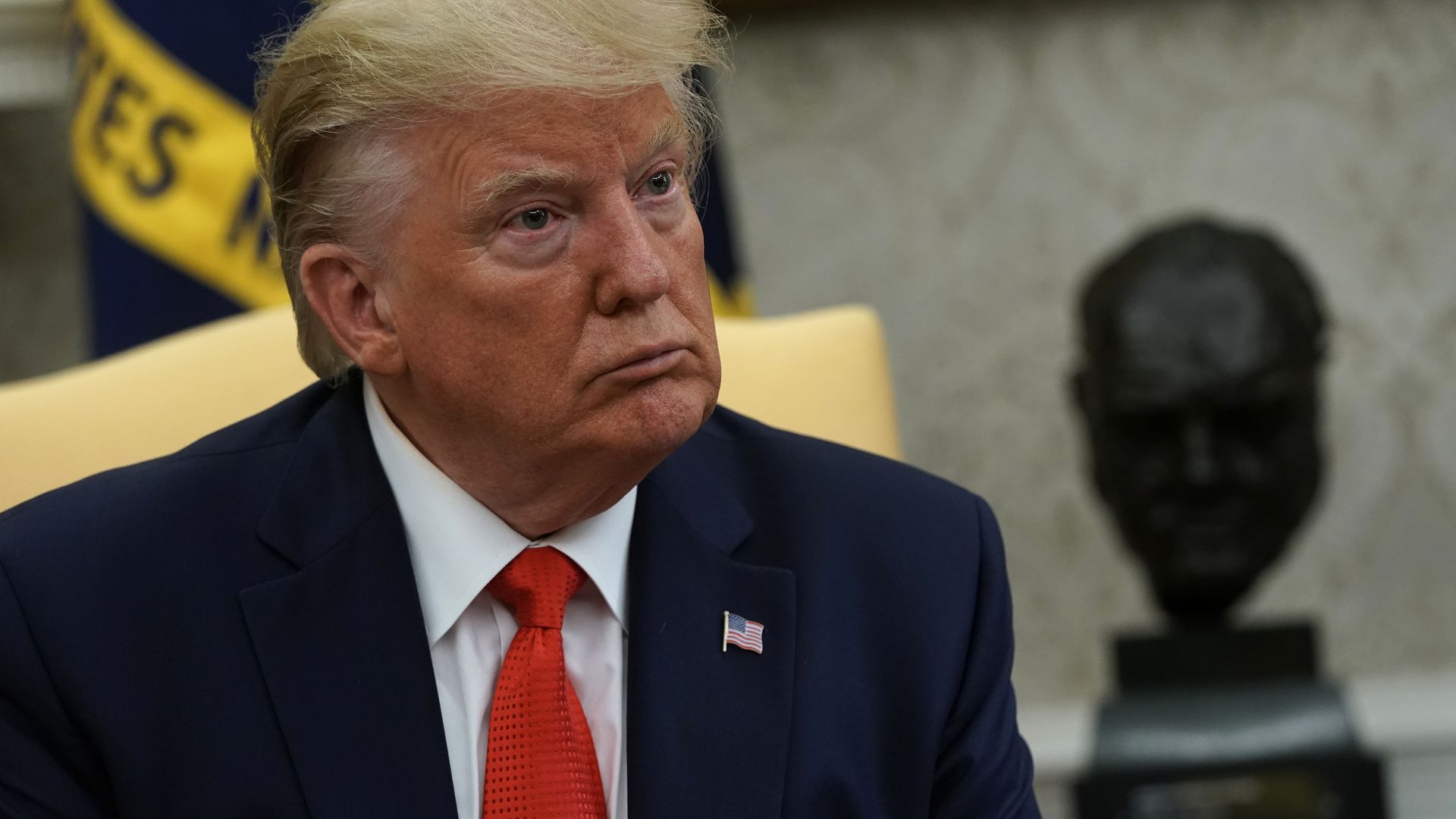 Donald Trump seated in the Oval Office