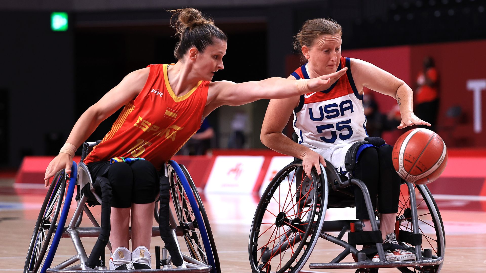 Two women play wheelchair basketball.