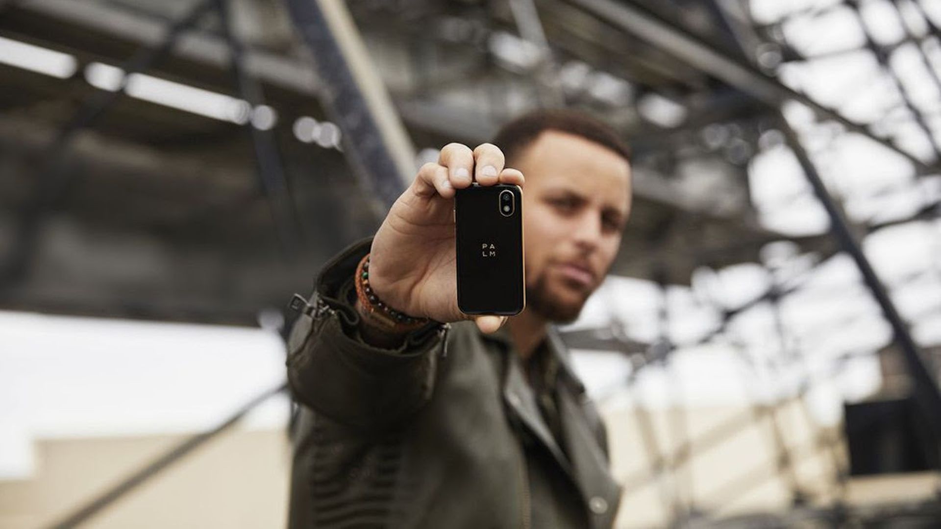Steph Curry holding up a Palm phone.