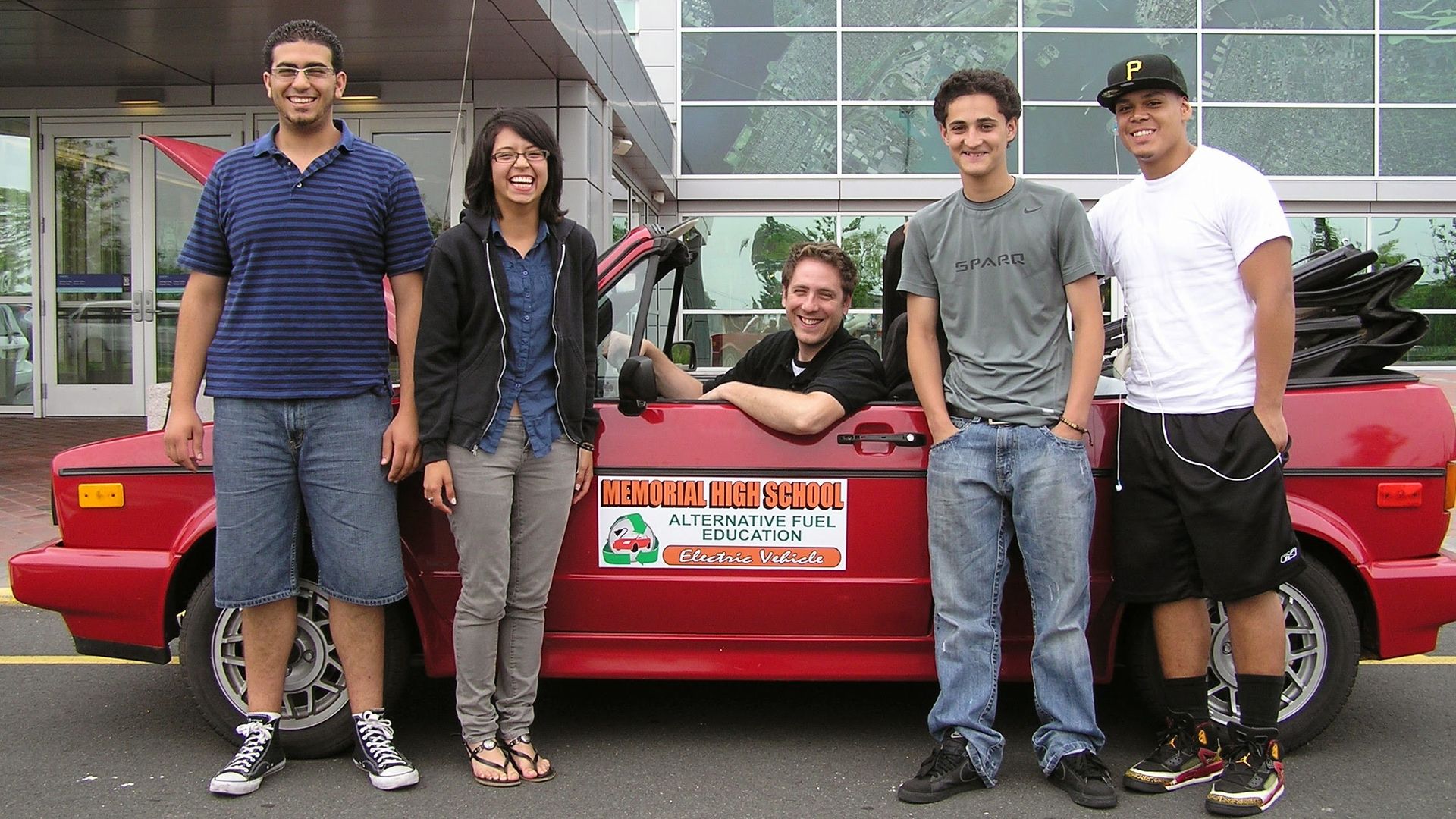 Image of Ron Grosinger and his students with a car converted to electric battery power