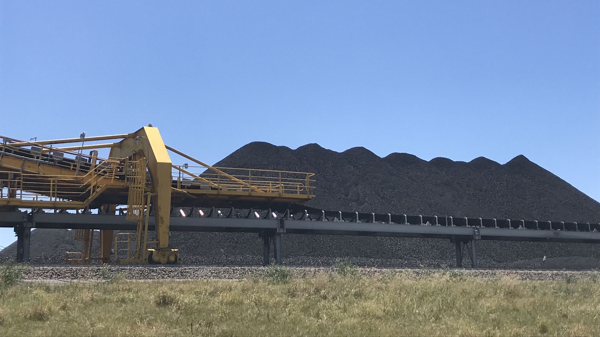 Pile of coal next to machinery.